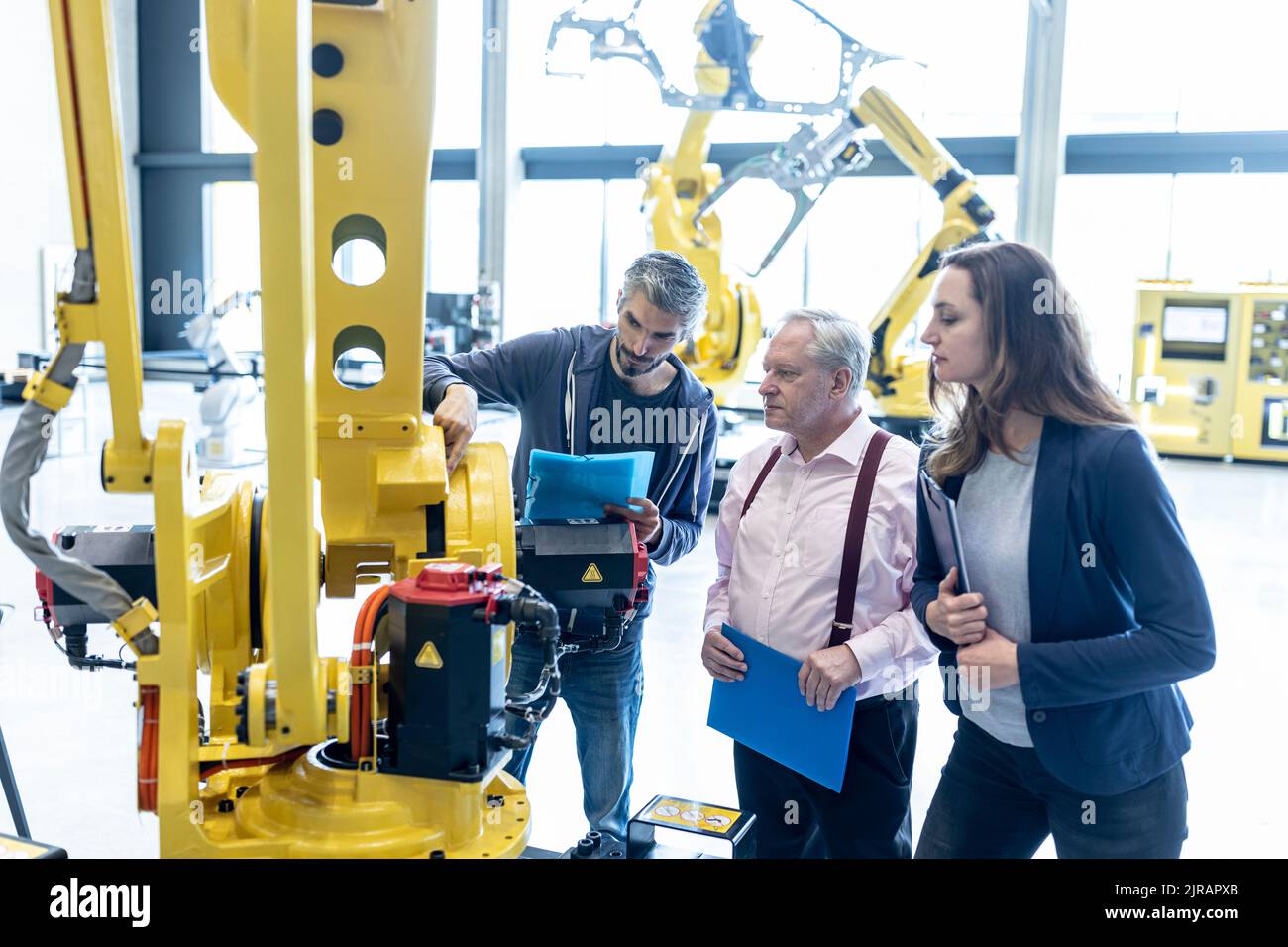 Techniker untersuchen Industrieroboter im Werk Stockfoto