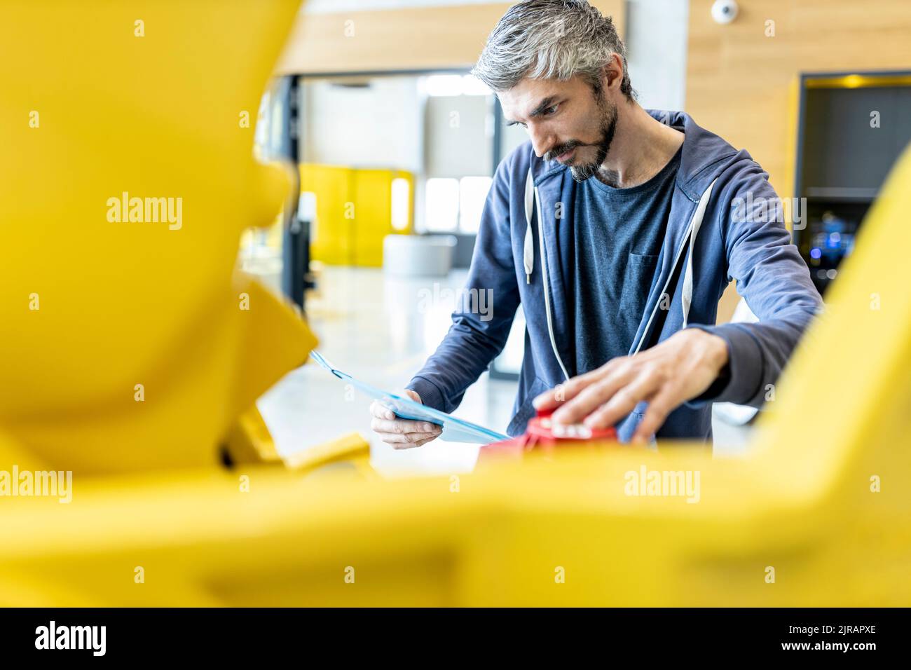 Techniker inspiziert Industrieroboter im Werk Stockfoto