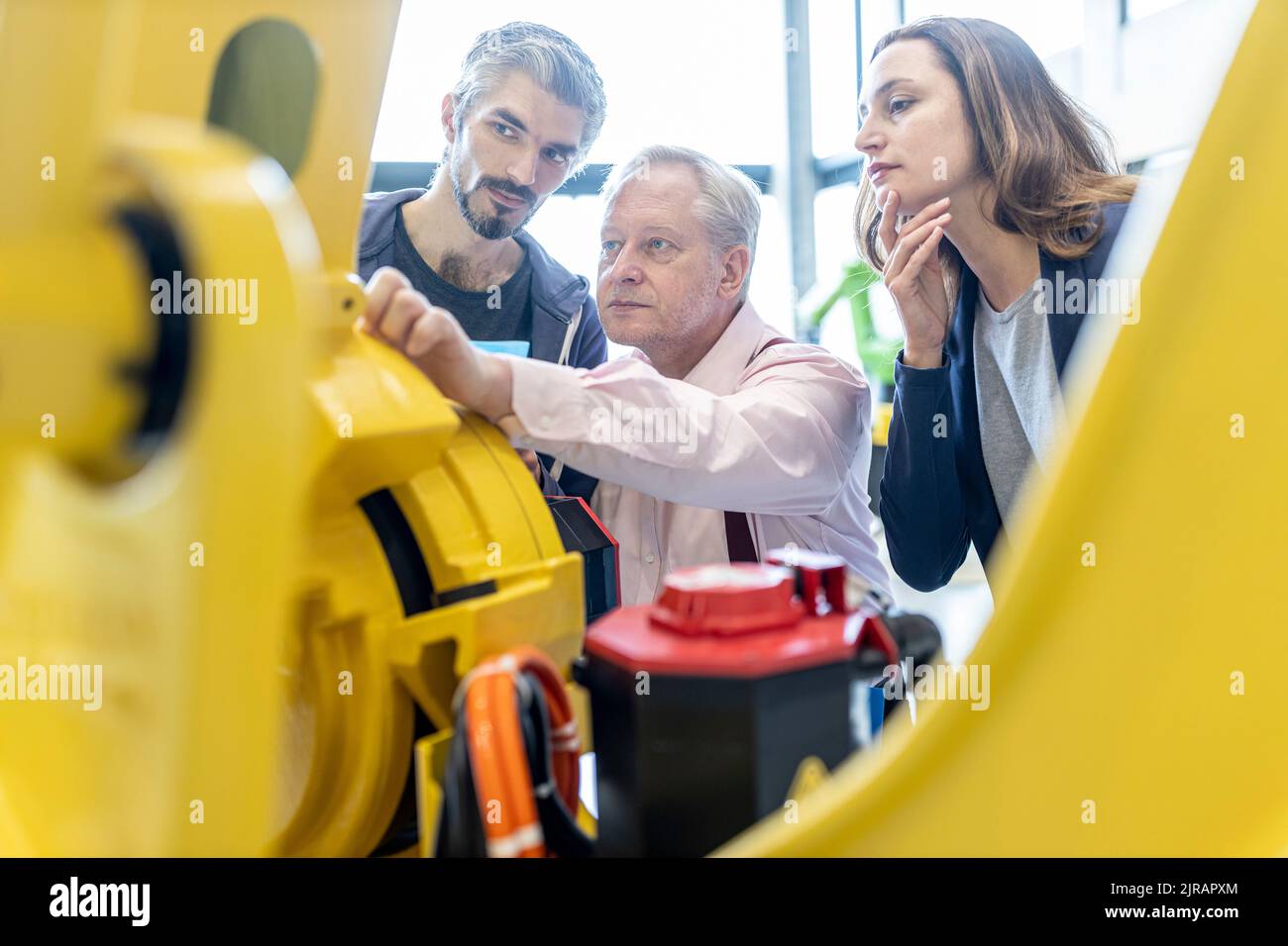 Techniker untersuchen Industrieroboter im Werk Stockfoto