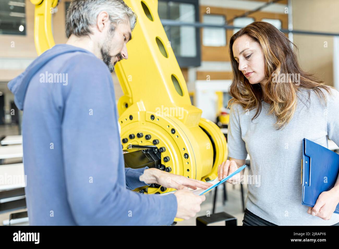 Techniker treffen sich vor einem Industrieroboter Stockfoto
