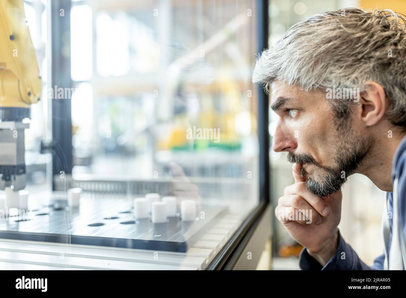 Ingenieure testen Industrieroboter in der Glaskabine Stockfoto