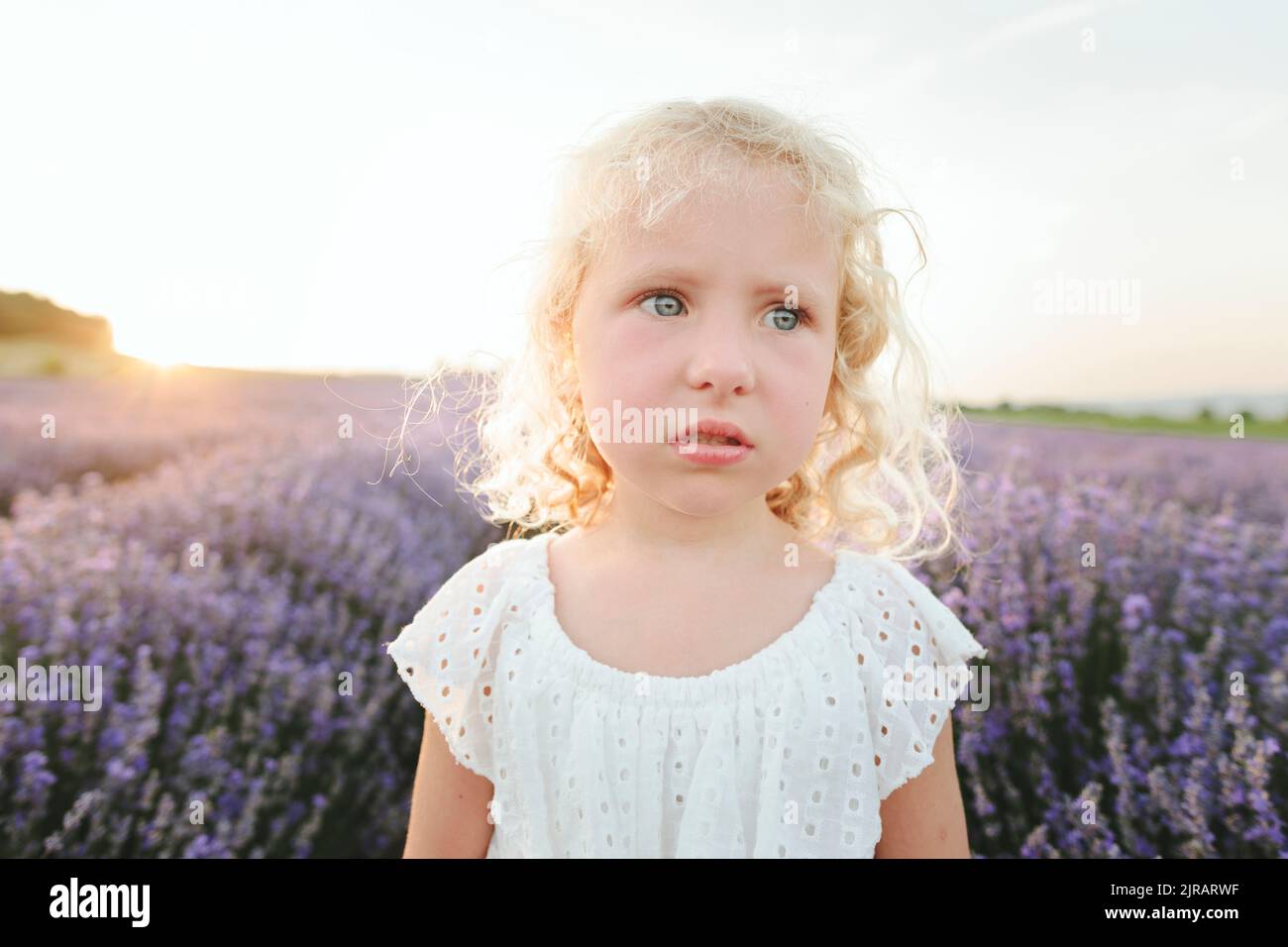 Trauriges Mädchen im Lavendelfeld bei Sonnenuntergang Stockfoto