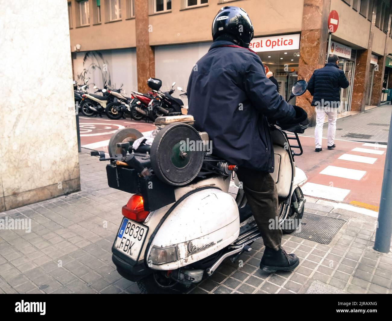 Ein Mann auf einer weißen italienischen Vespa in Barcelona Stockfoto