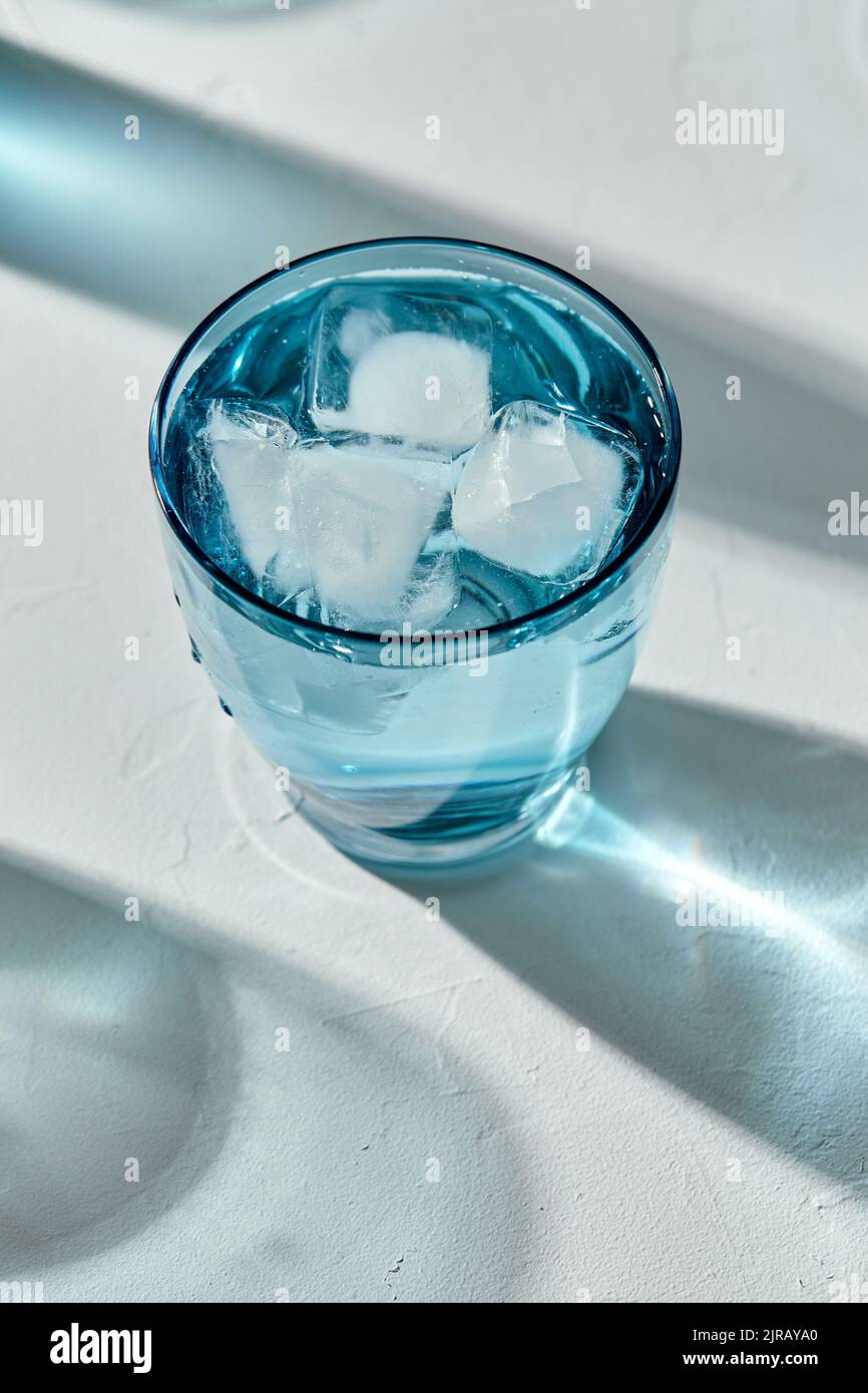 Blaues Glas kaltes Wasser mit Eiswürfeln Stockfoto