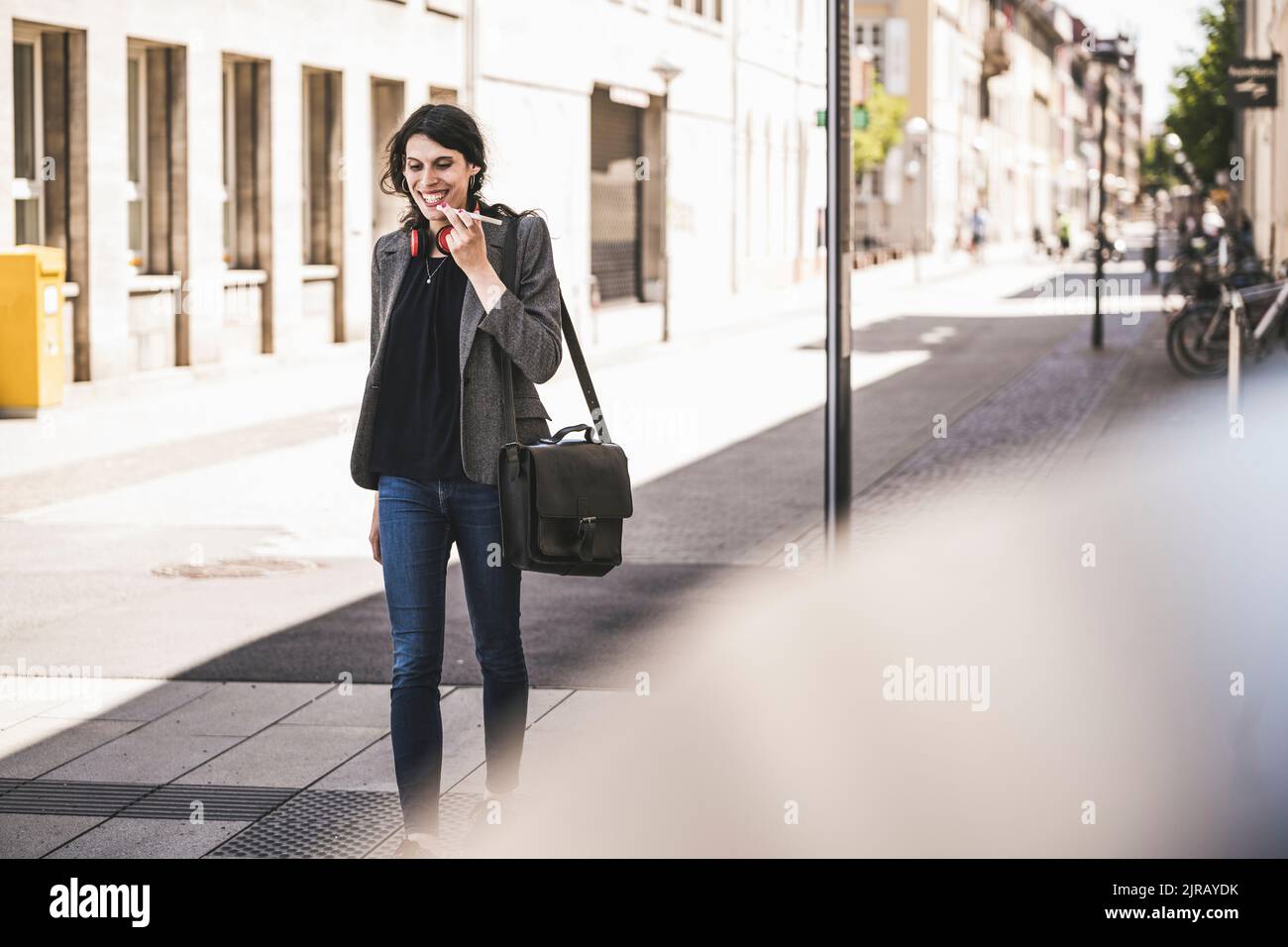 Lächelnde junge Transgender-Geschäftsfrau, die am Telefon spricht Stockfoto