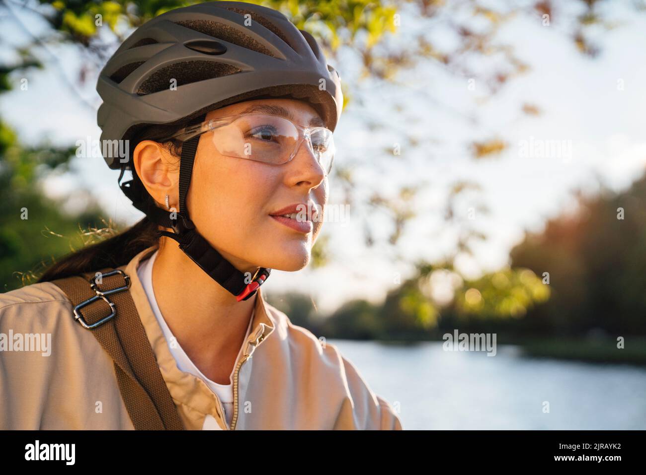 Frau mit Fahrradhelm und Schutzbrille im Park Stockfoto
