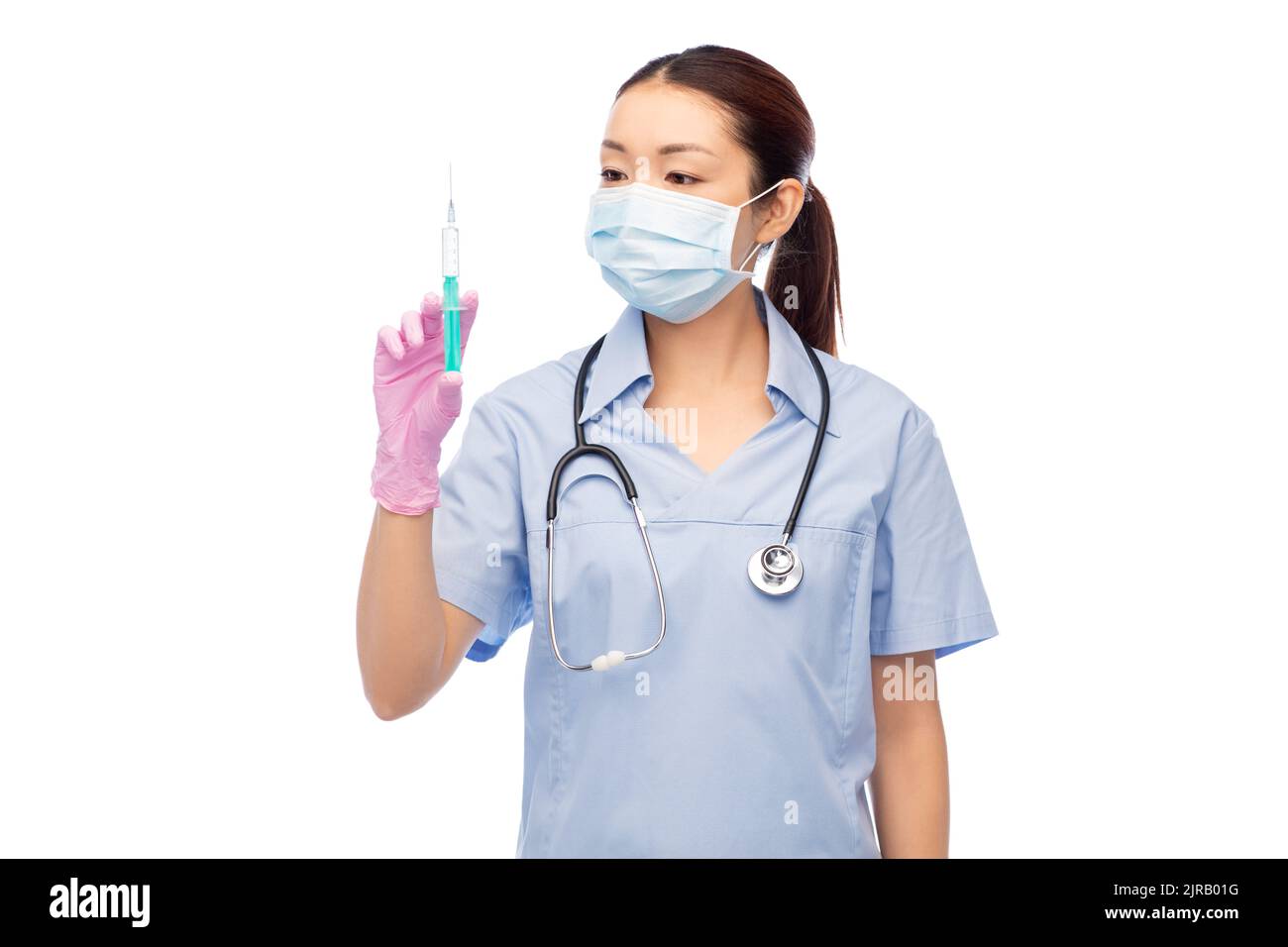 asiatische Krankenschwester in Maske mit Medizin in Spritze Stockfoto