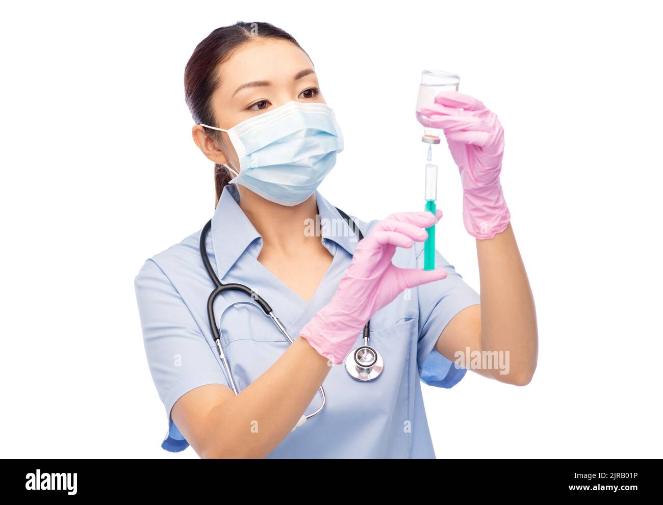 asiatische Krankenschwester in Maske mit Medizin in Spritze Stockfoto