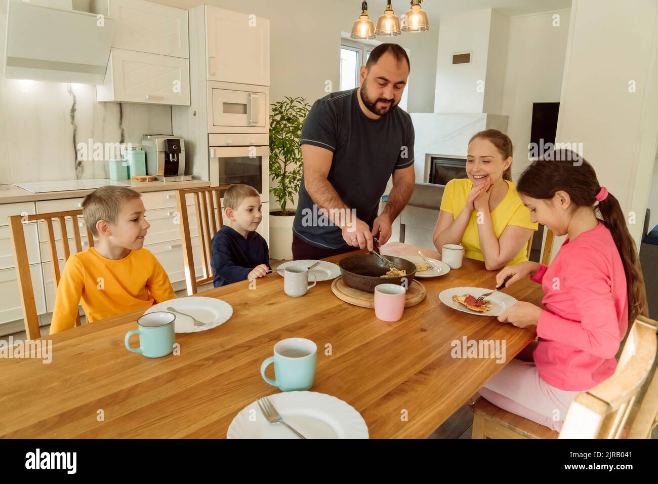 Mann, der der Familie zu Hause das Frühstück serviert Stockfoto