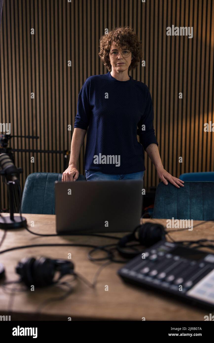 Radio-DJ steht am Schreibtisch im Aufnahmestudio Stockfoto