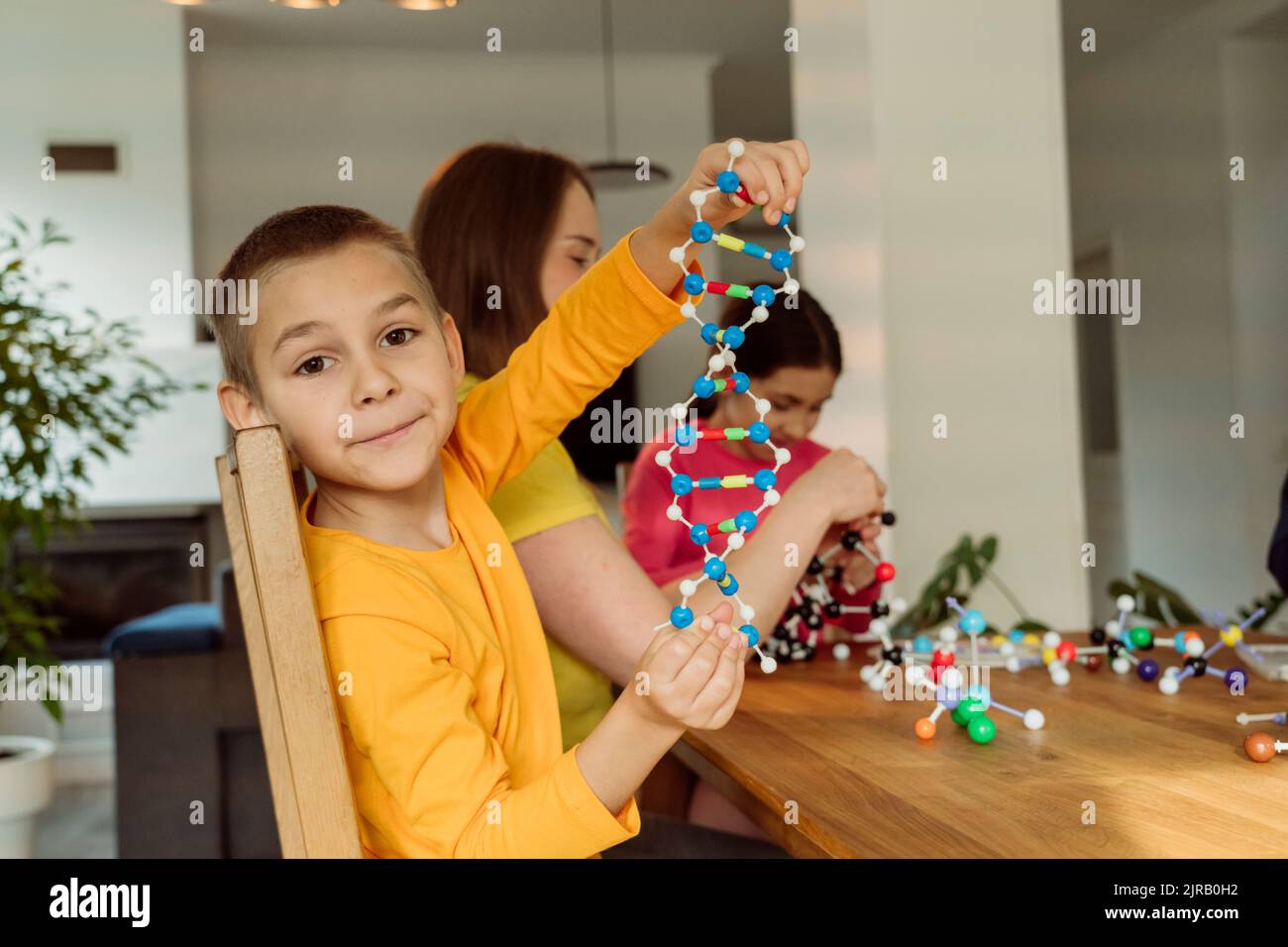 Junge mit Helix-Modell von Mutter zu Hause Stockfoto