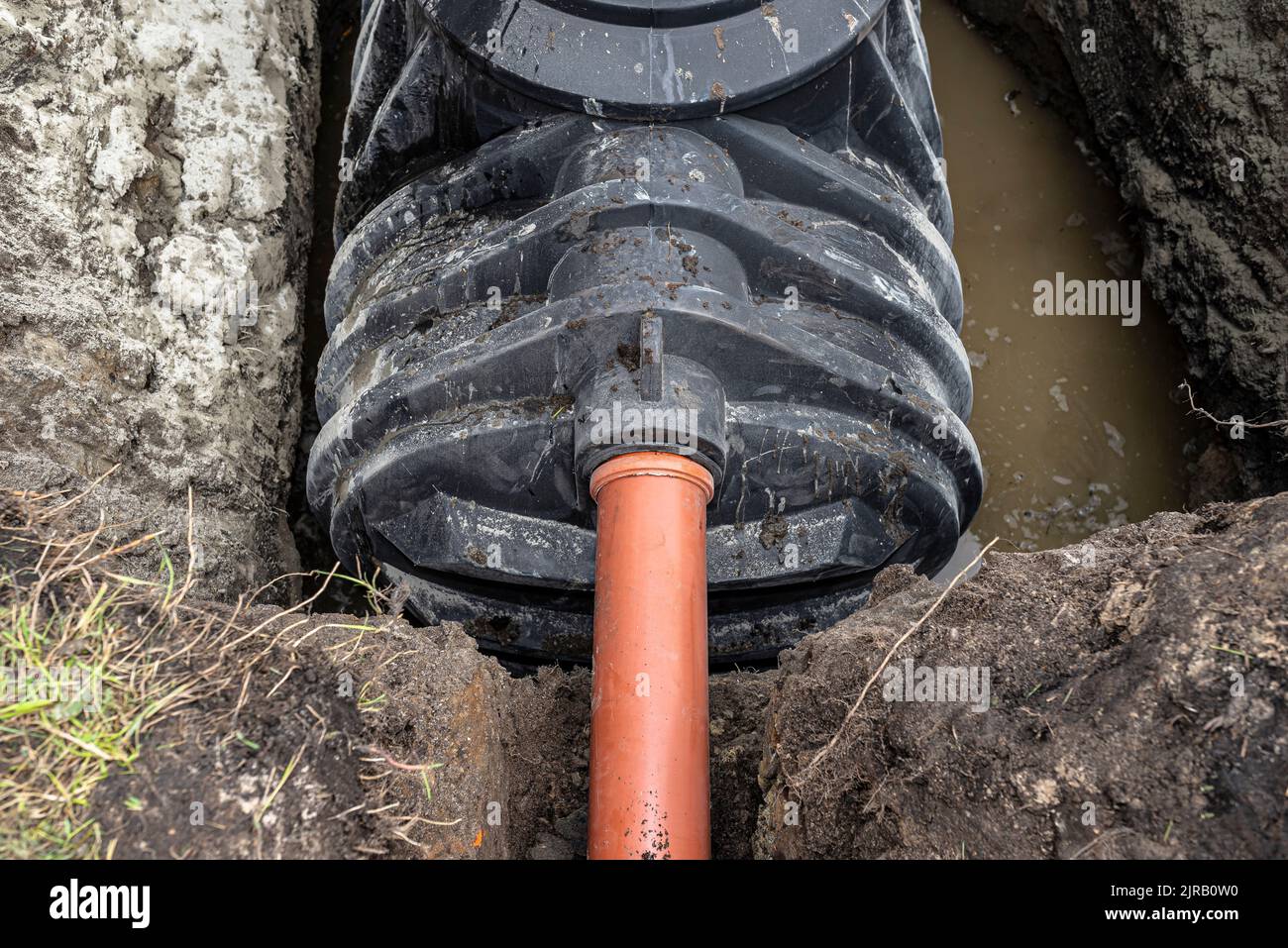 Ein Kanalrohr mit einem Durchmesser von 160 mm gelangt in den Klärtank, Installation einer Einkammer-Hauskläranlage. Stockfoto