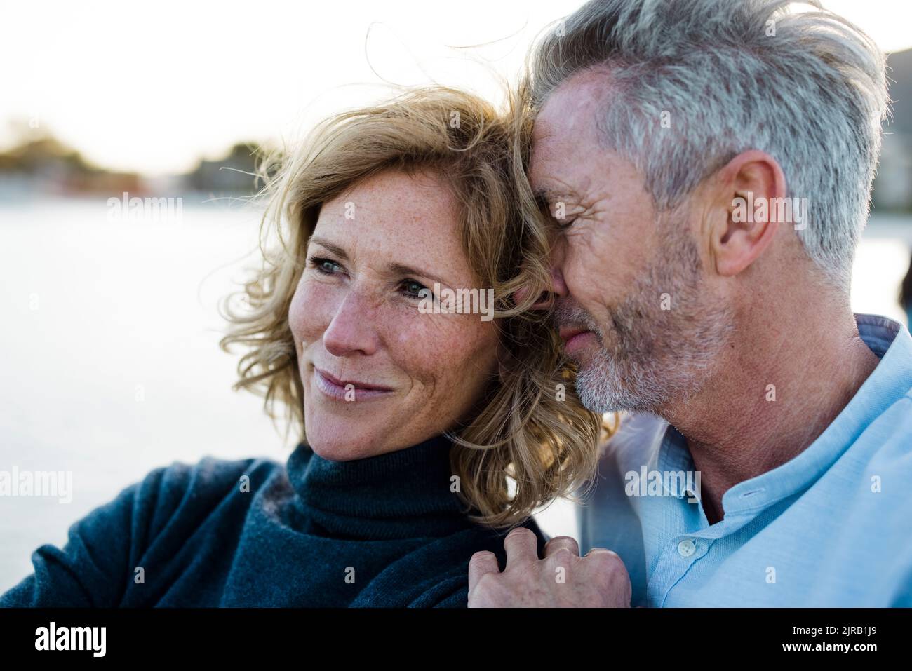 Lächelnder reifer Mann umarmt Frau im Urlaub Stockfoto