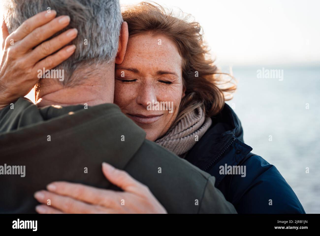 Lächelnde reife Frau umarmt Mann im Urlaub Stockfoto