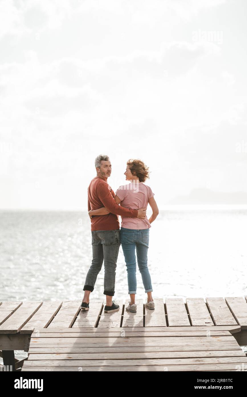 Reifes Paar mit Arm um stehen auf Pier Stockfoto