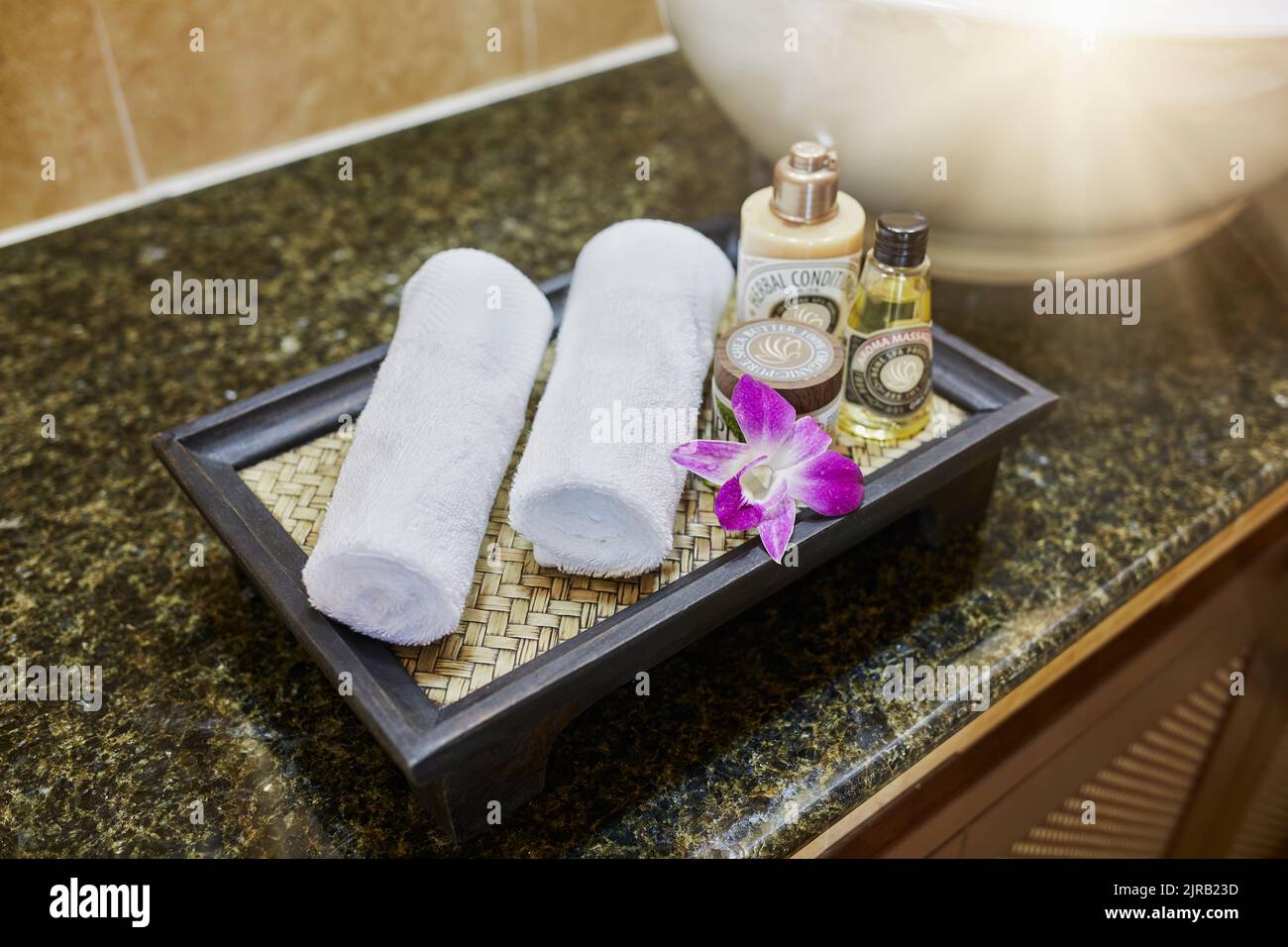 Frisches Handtuch mit Wellness-Kosmetik im Badezimmer Stockfoto