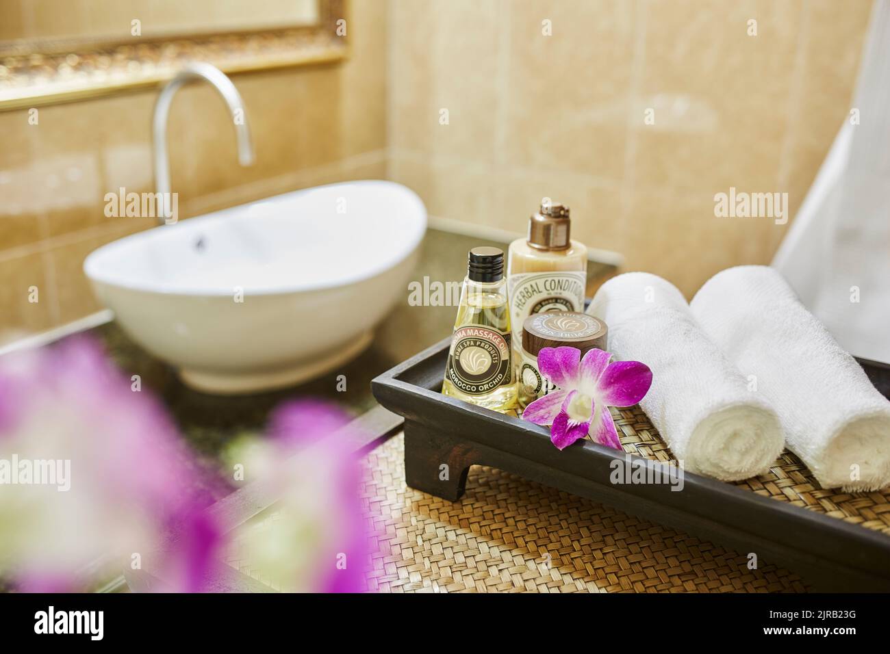 Ätherische Öle mit frisch gerollten Handtüchern im Badezimmer Stockfoto