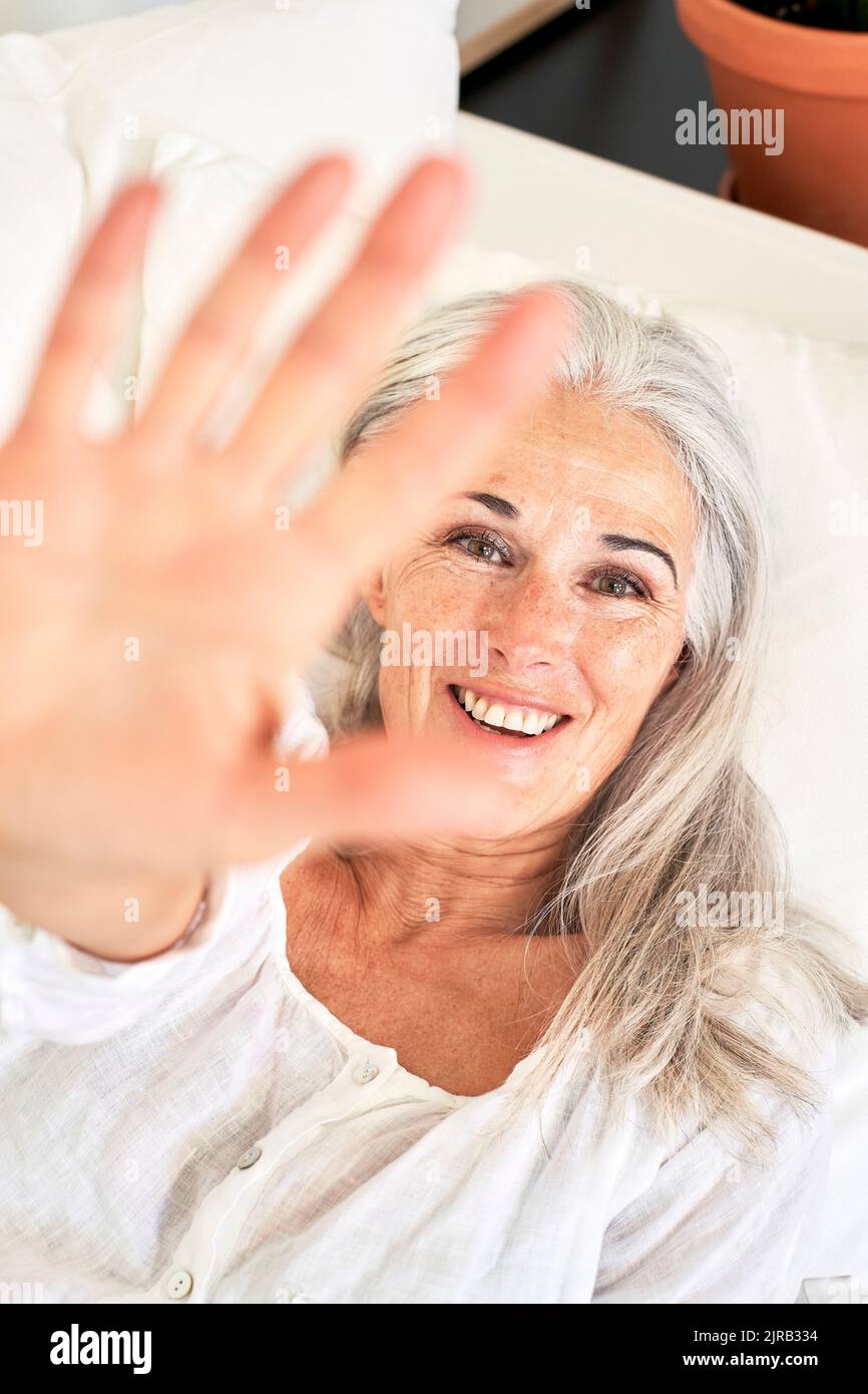 Lächelnde Frau mit Stop-Geste Stockfoto