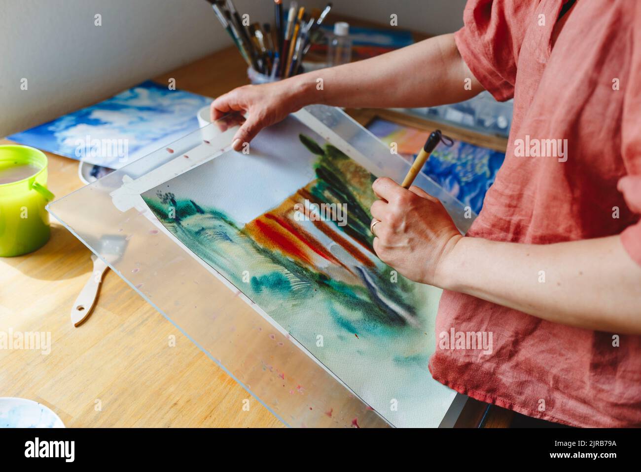 Künstler mit Pinsel Malerei auf Papier Stockfoto