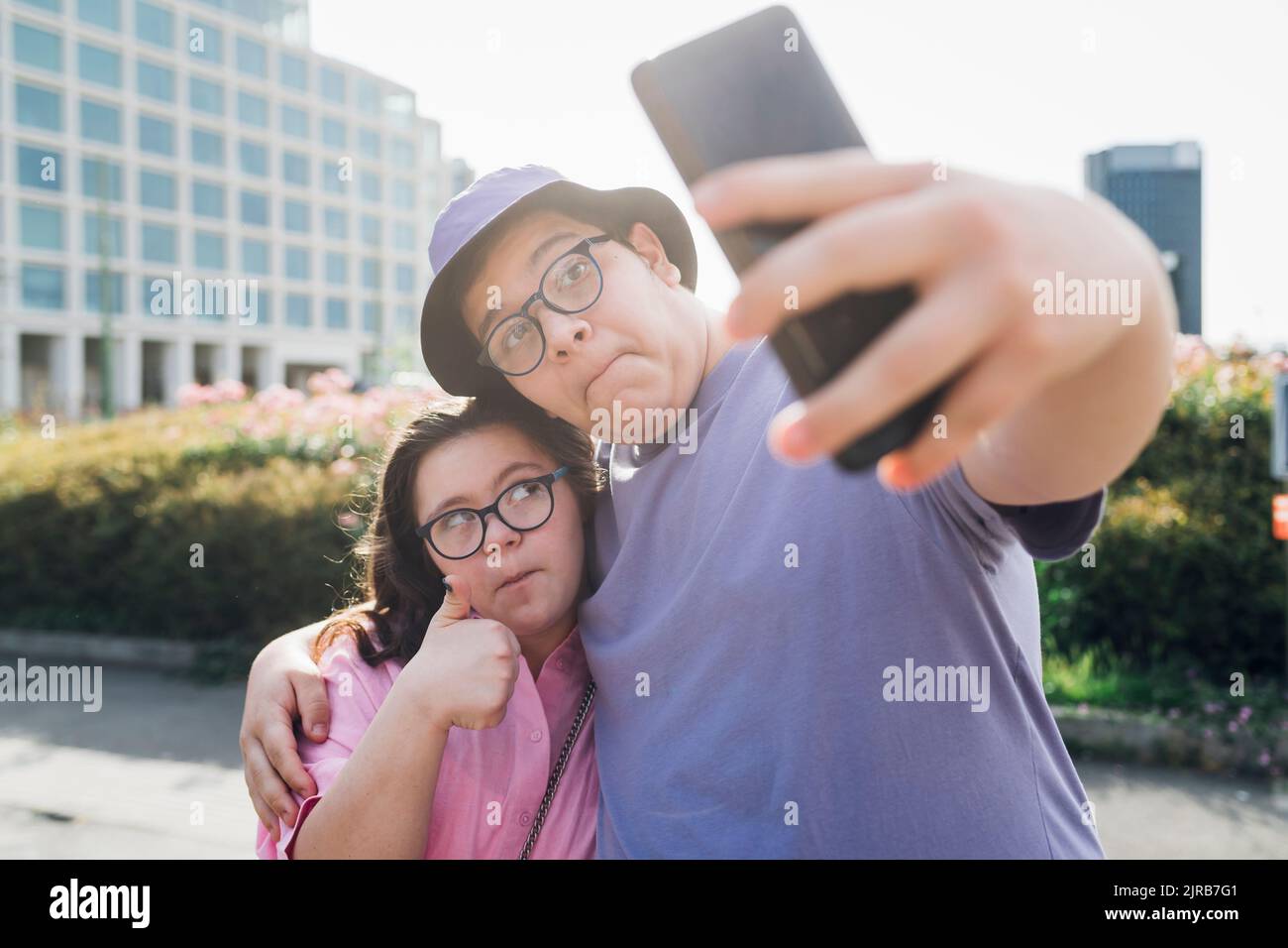 Mädchen und Jungen im Teenageralter machen Gesichter und machen Selfie über das Mobiltelefon Stockfoto