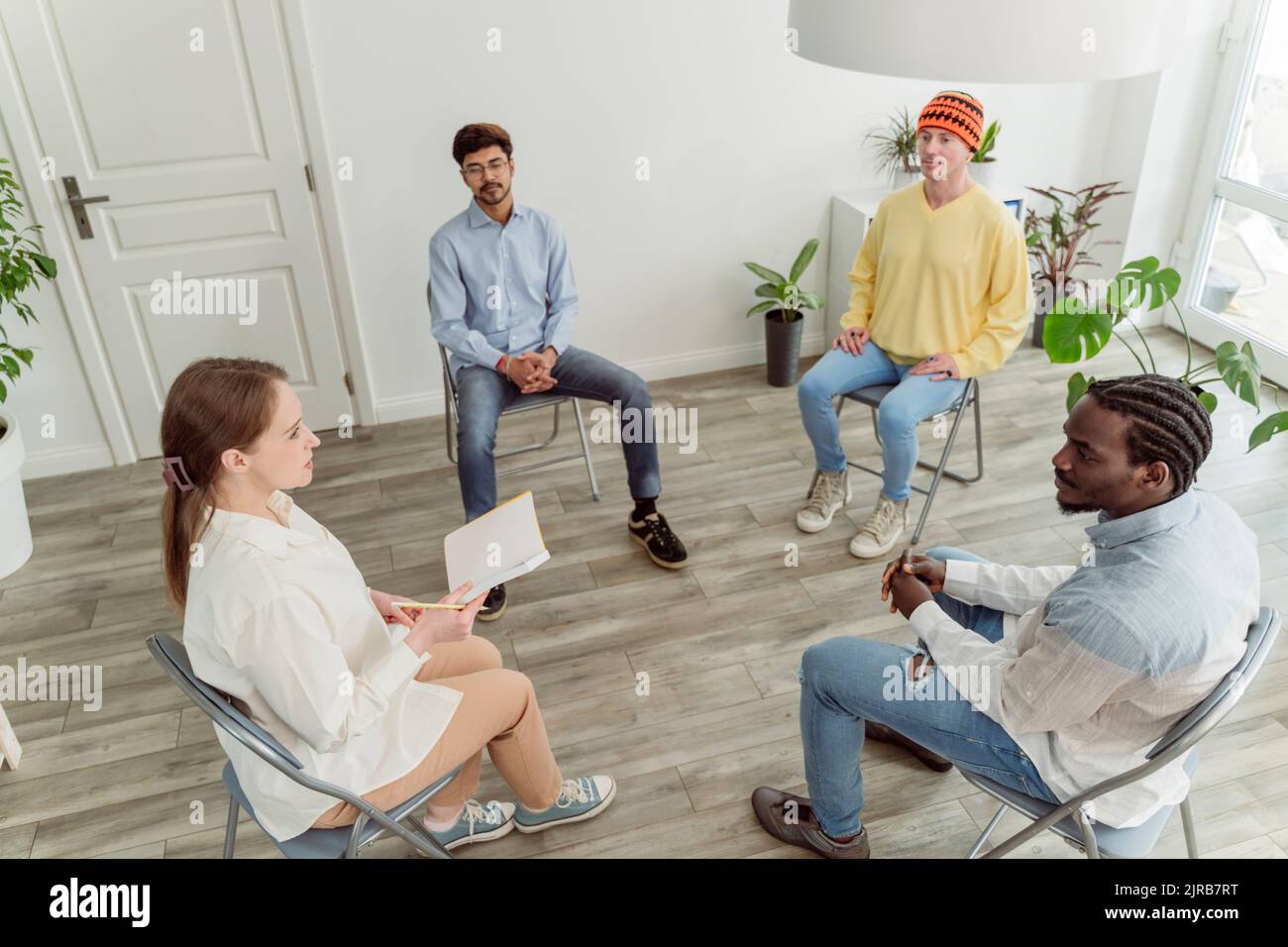 Psychologe im Gespräch mit Mann in der Gruppentherapie Stockfoto