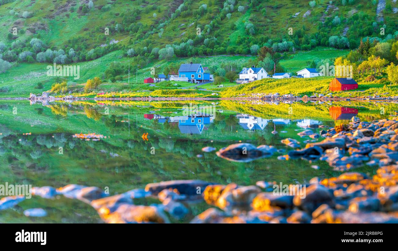 Norwegen, Nordland, Küste der Insel Vestvagoya mit abgeschiedenen Häusern im Hintergrund Stockfoto