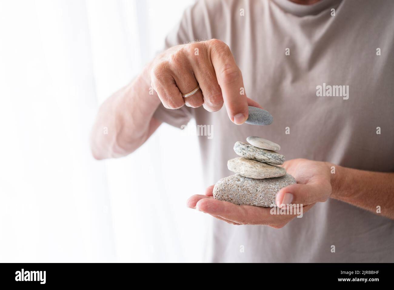 Mann, der zu Hause Steine stapelt Stockfoto