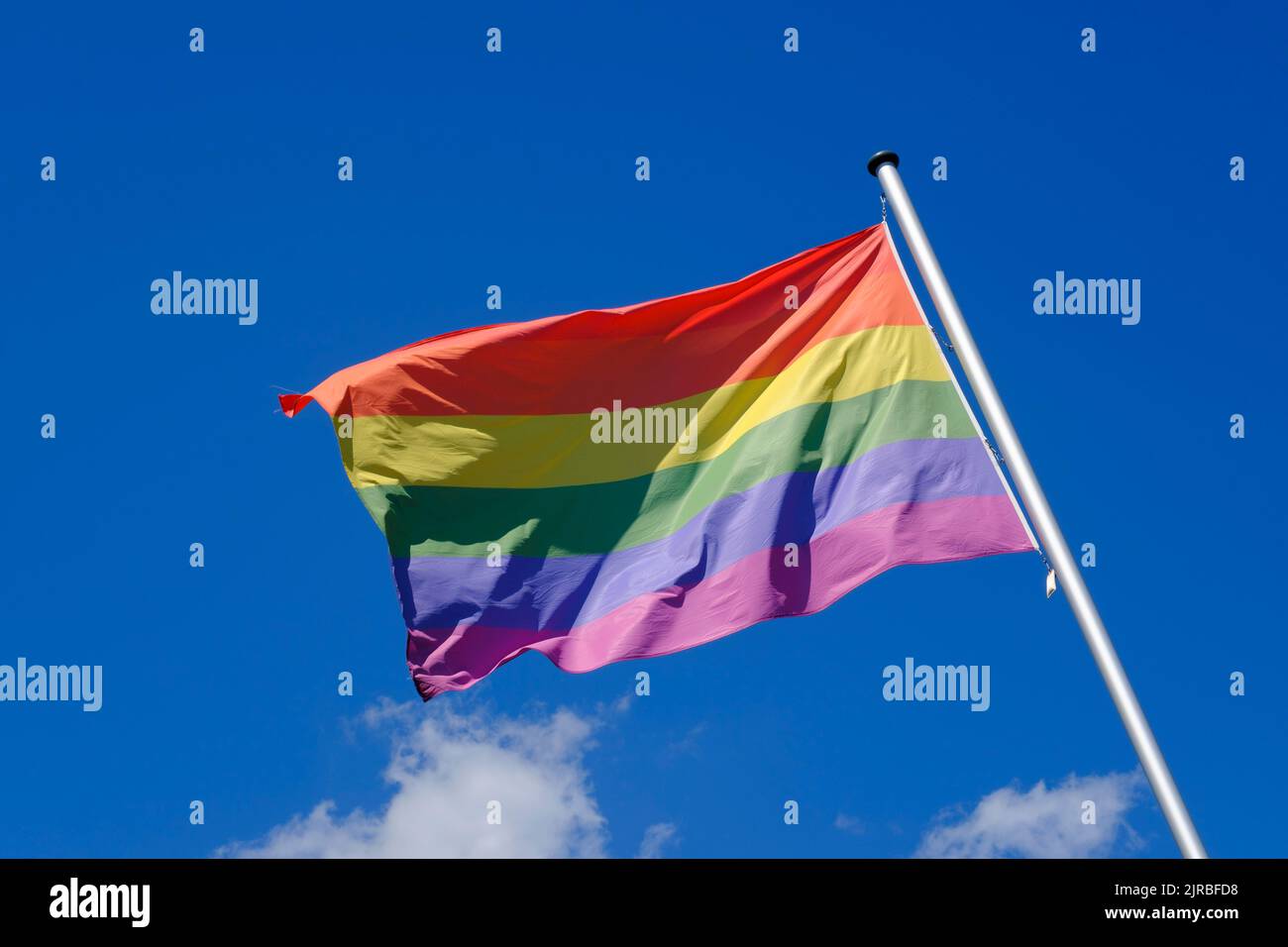 Regenbogenfahne flattert gegen den Himmel Stockfoto