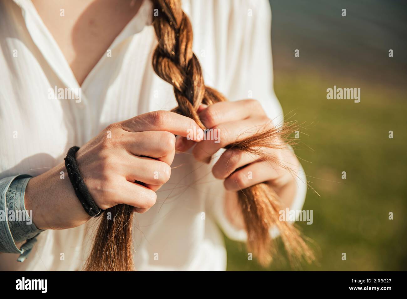 Junge Frau, ihr Haar zu flechten Stockfoto