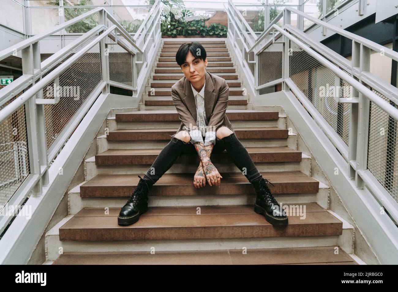 Geschäftsfrau mit kurzen Haaren auf Stufen sitzend Stockfoto