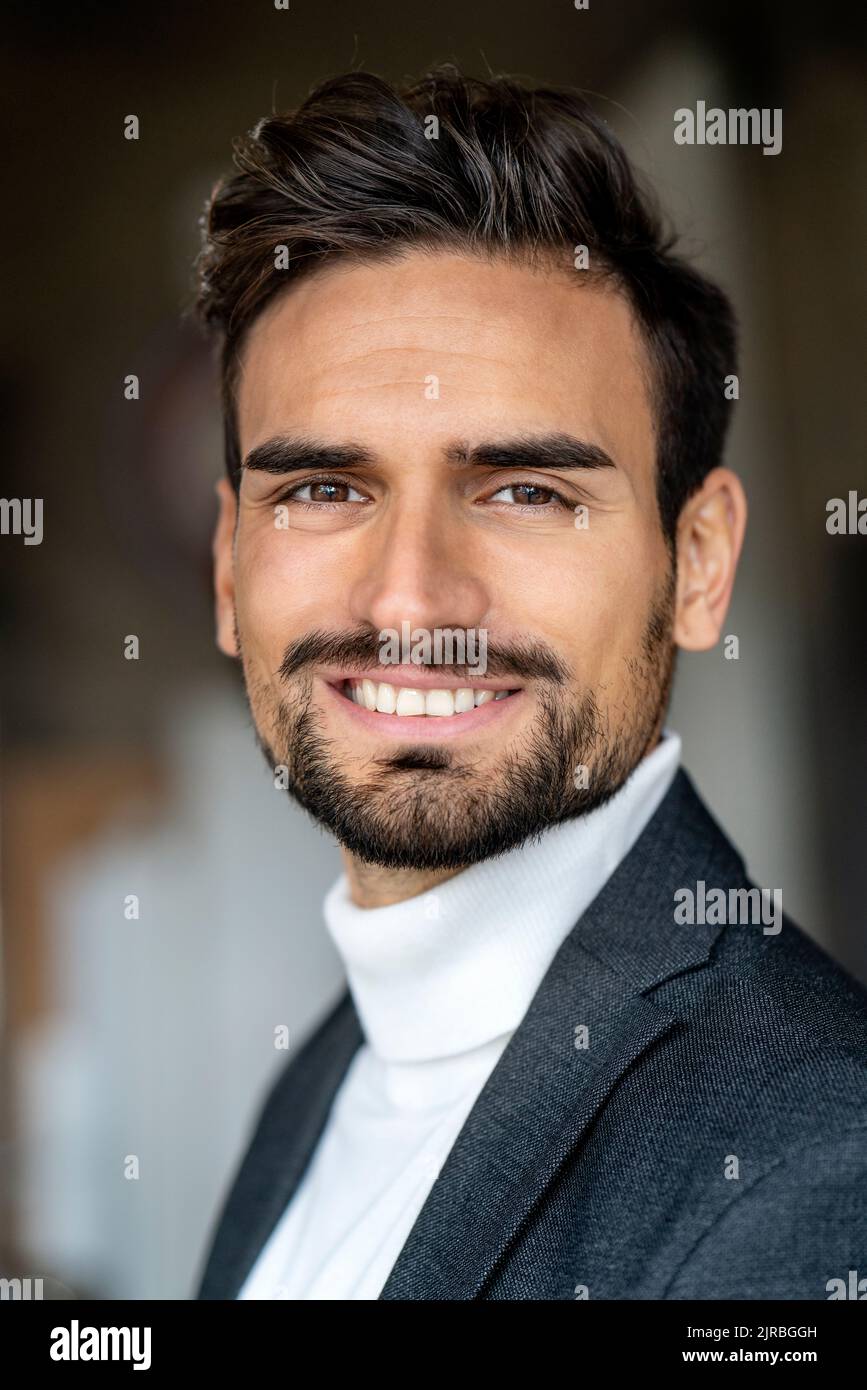 Lächelnder, hübscher junger Geschäftsmann mit Rollkragen Stockfoto