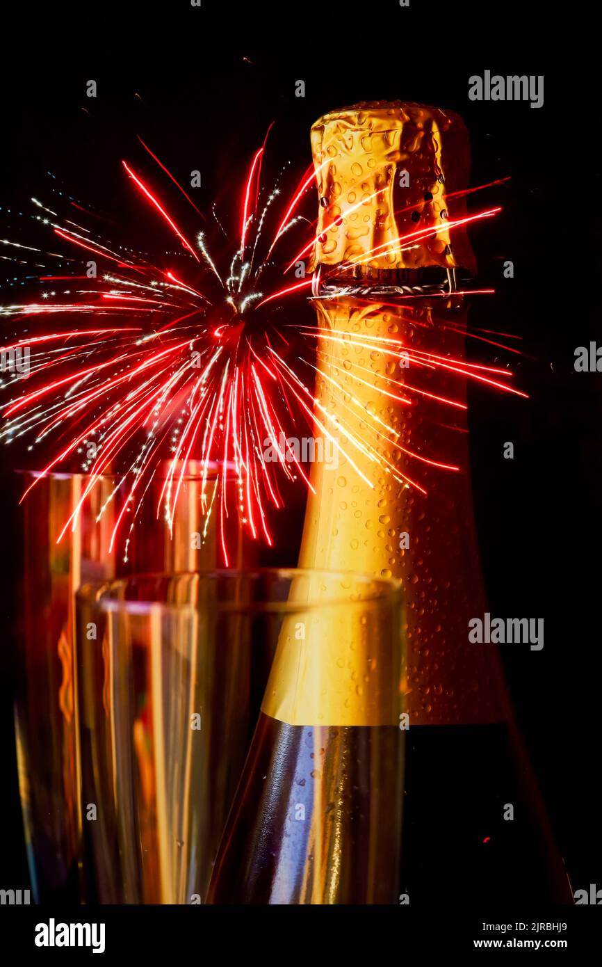 Flasche Champagner gegen explodierende Feuerwerke Stockfoto