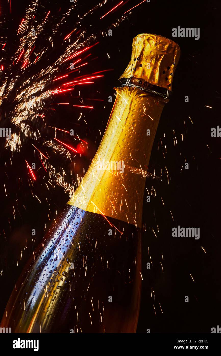 Flasche Champagner gegen explodierende Feuerwerke Stockfoto