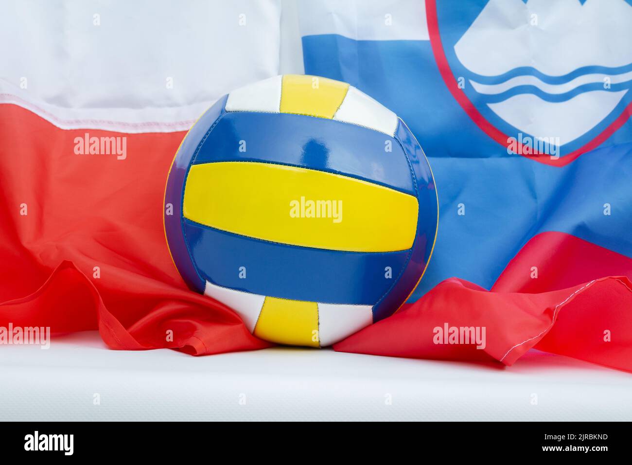 Volleyball mit Flaggen von Polen und Slowenien. WM Gastgeber Länder Sport Hintergrund. Stockfoto