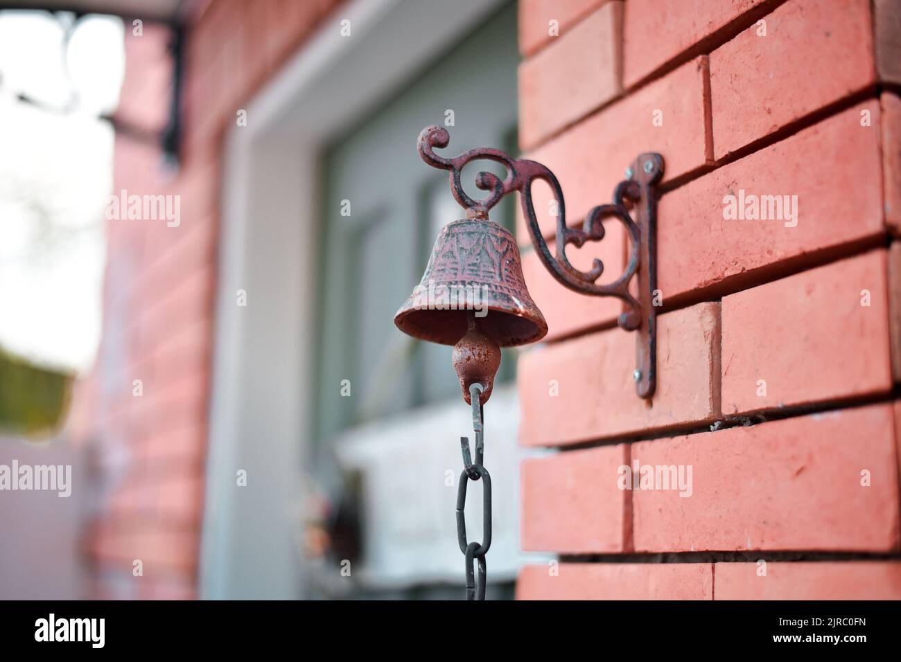 Eine Nahaufnahme einer metallischen Glocke, die an einer Steinwand befestigt ist Stockfoto