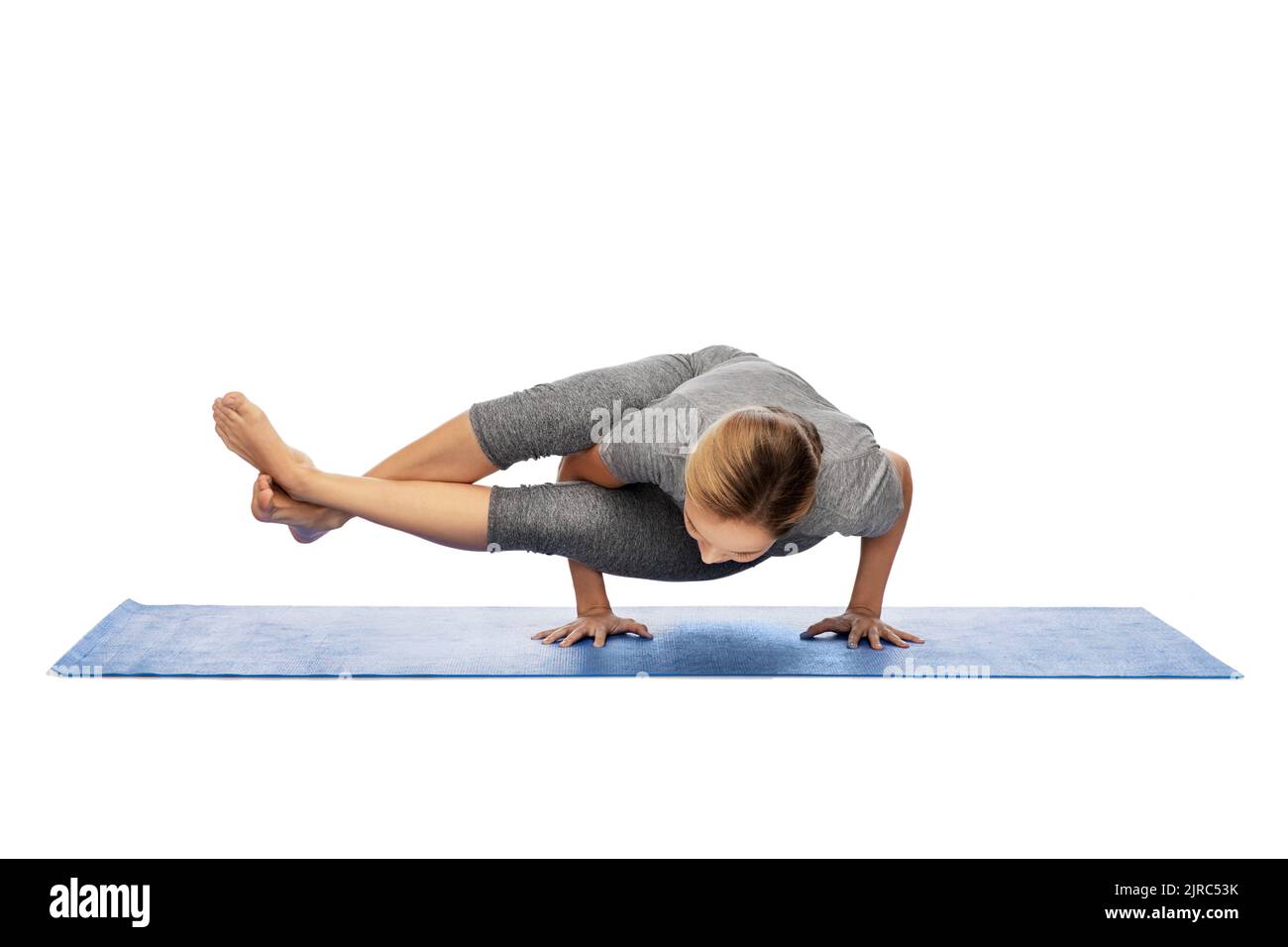 Frau, die Yoga im Handstand auf der Matte macht Stockfoto