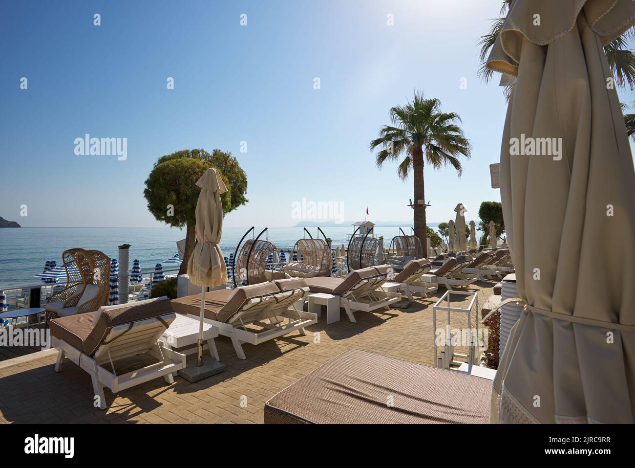 Schöner leerer Strand mit Sonnenschirmen und Sonnenliegen. Perfektes Sommerurlaubsziel in Kreta - Griechenland Stockfoto