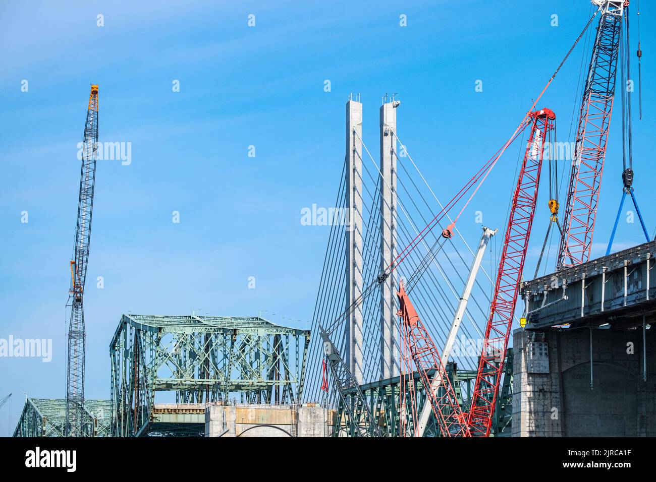 Eine alte Brücke wird gerade abgerissen, neben einer neuen Brücke mit Kabelgestasten. Stockfoto