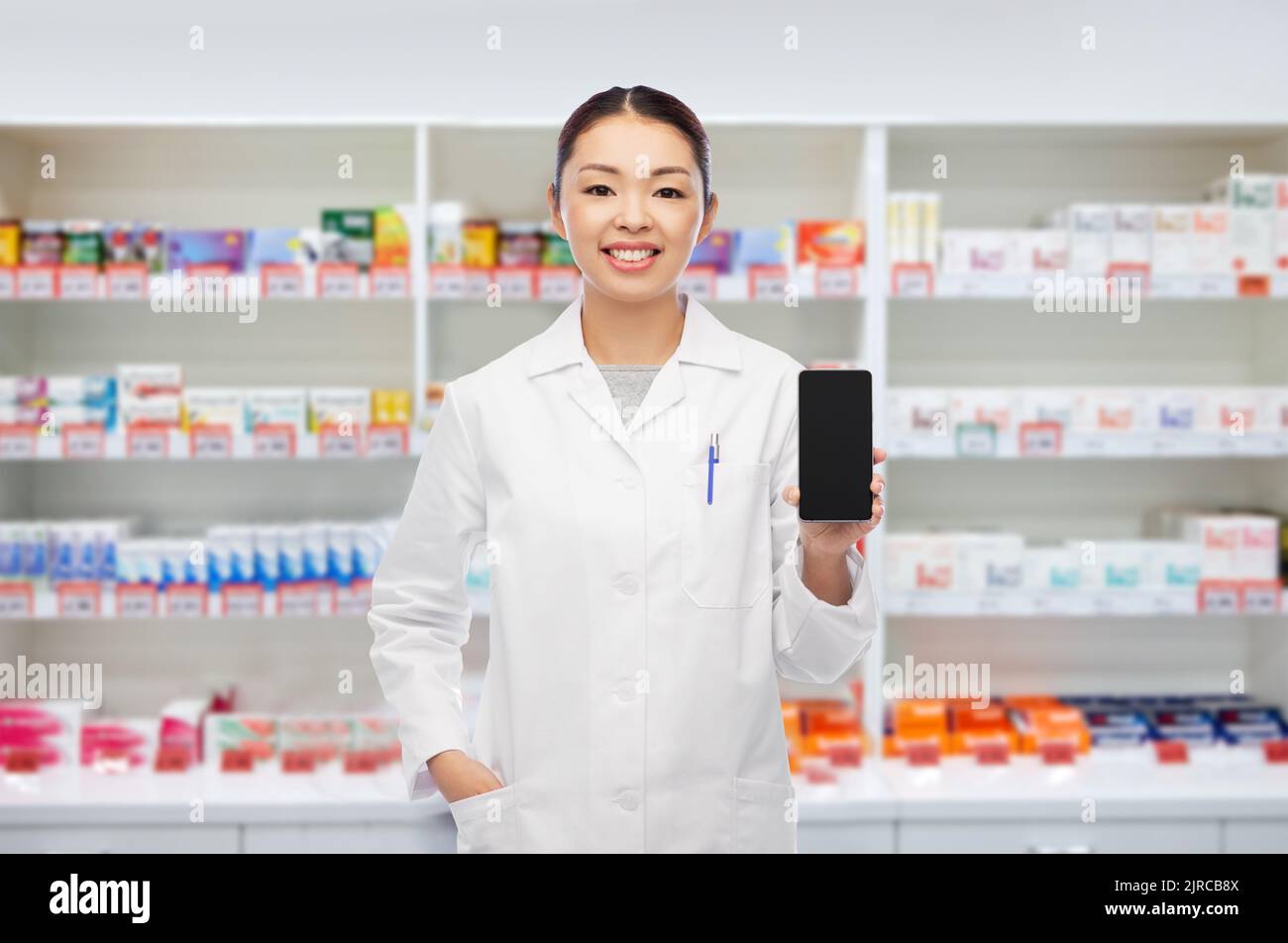asiatischer Apotheker mit Smartphone in der Apotheke Stockfoto