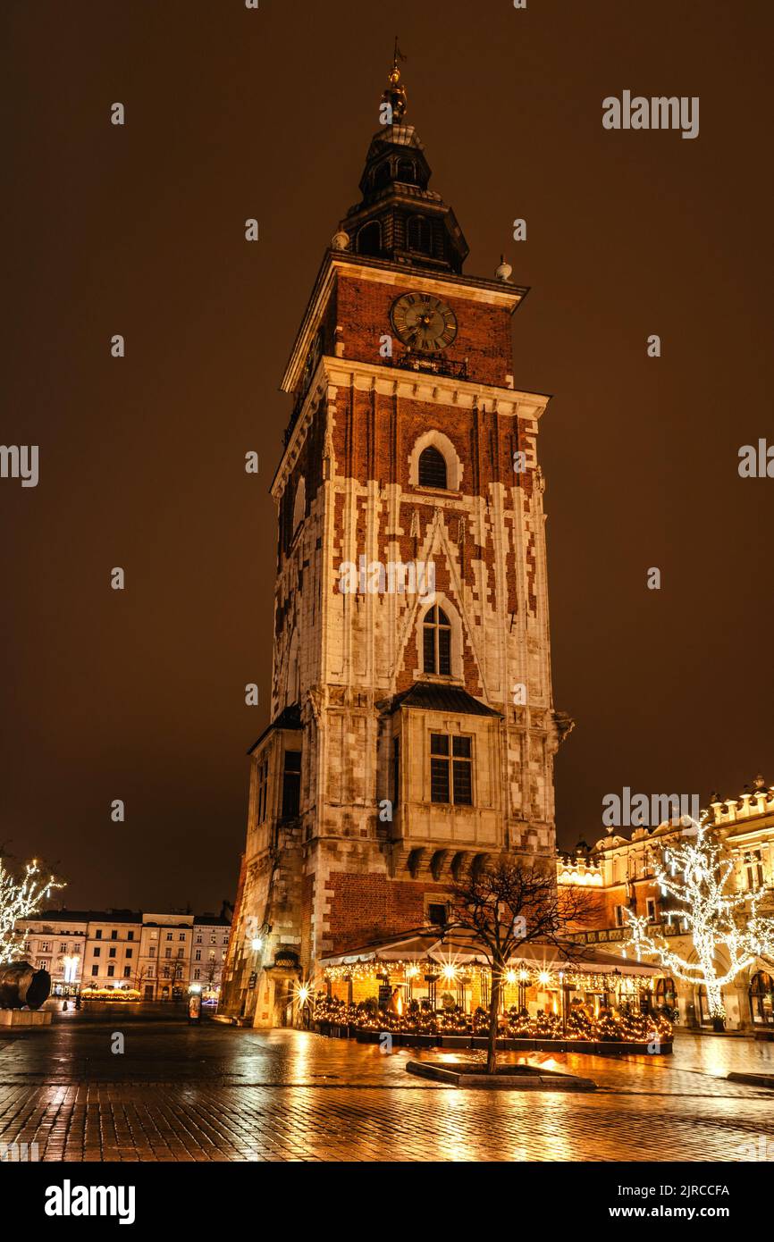 Krakau nach dem Regen, Polen. Hauptplatz mit berühmten Weihnachtsmärkten, Rynek Glowny in der Nacht mit Reflexion, dekoriert Weihnachtsbaum. Festliche Atmosphäre, verschwommen Stockfoto