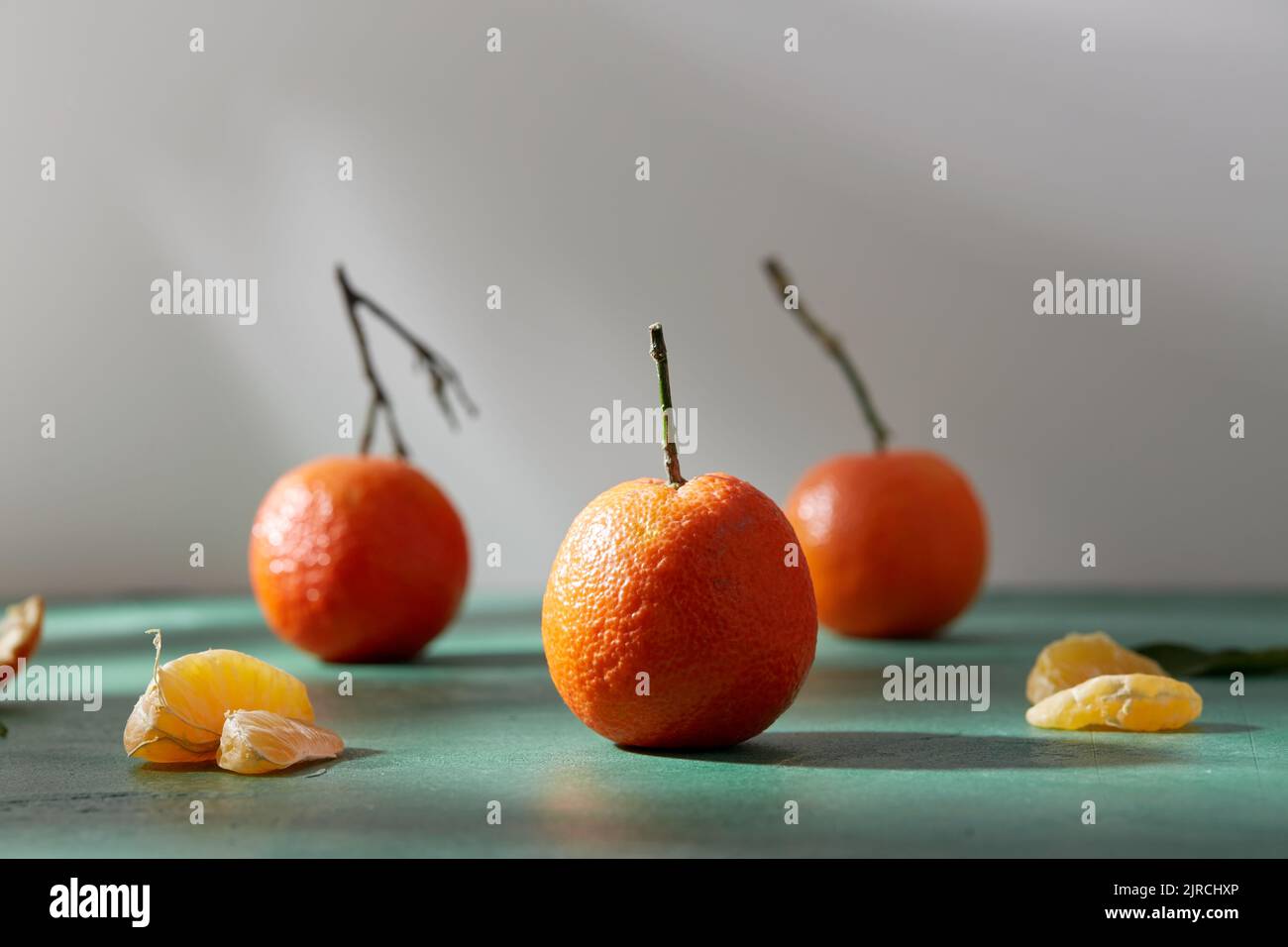 Stillleben mit Mandarinen auf grünem Hintergrund Stockfoto