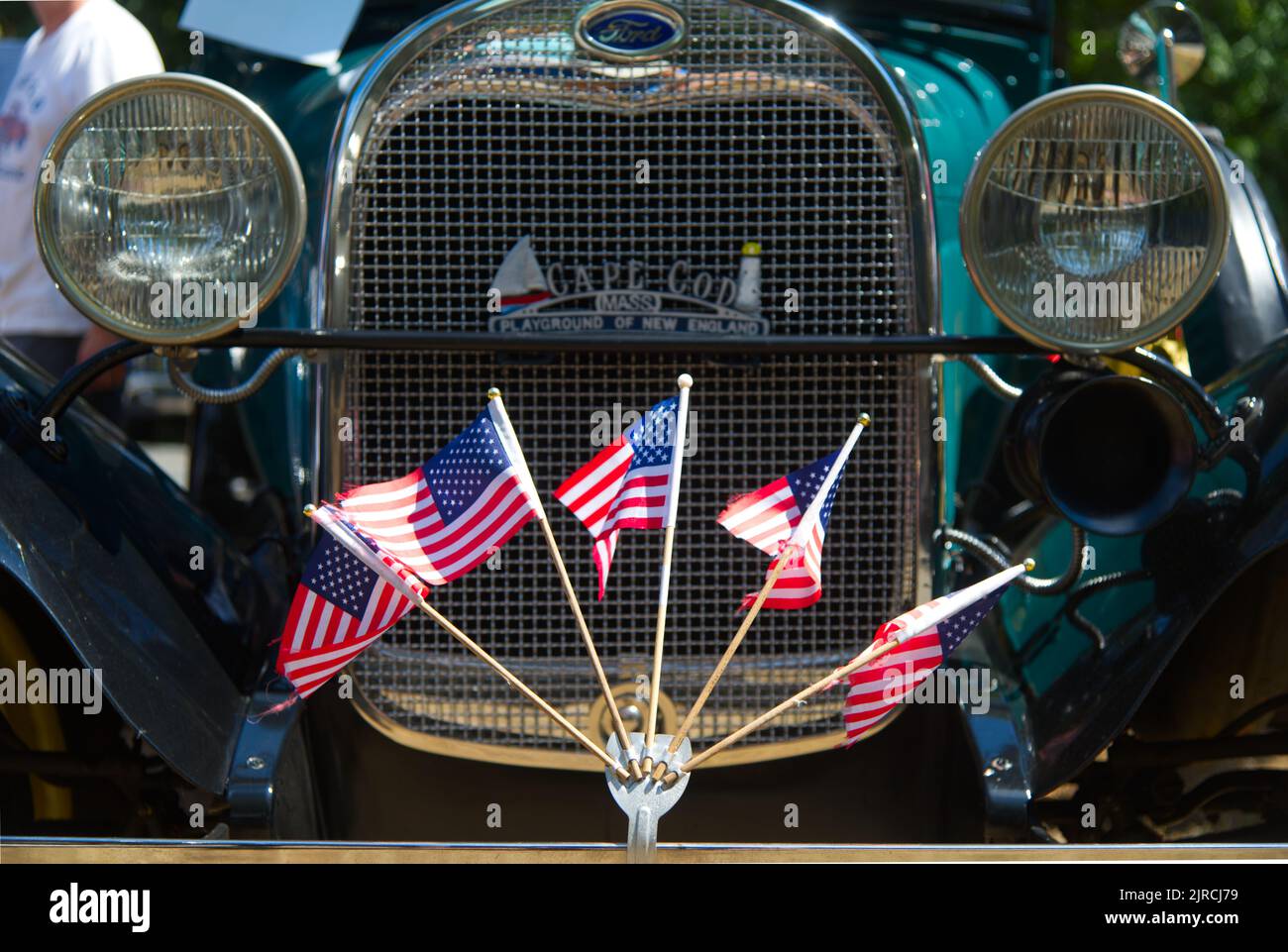 US-Flaggen fliegen auf dem vorderen Stoßfänger einer restaurierten antiken Ford in einer antiken Auto-Parade in Dennis, Massachusetts, Cape Cod, USA Stockfoto