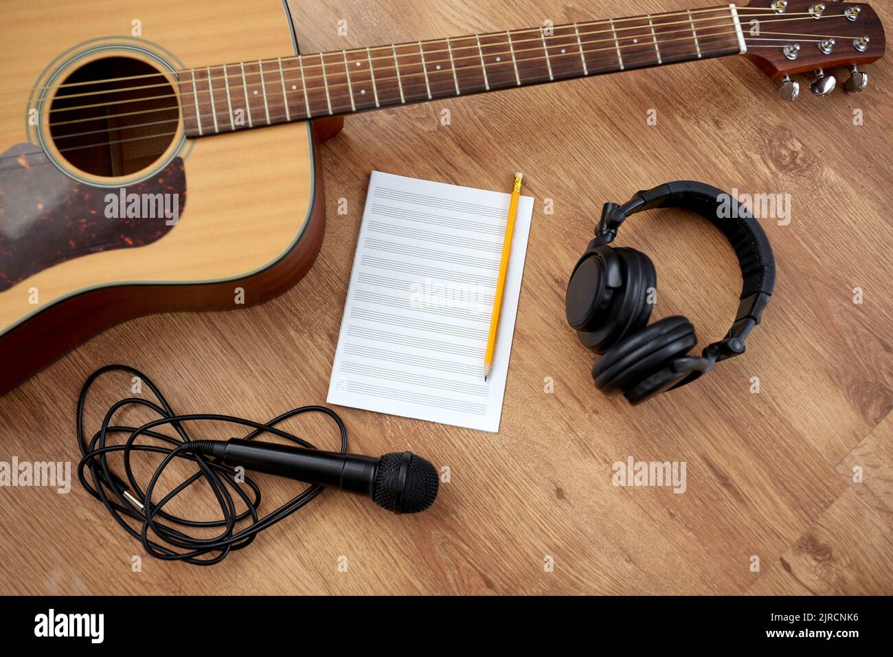 Gitarre, Musikbuch, Mikrofon und Kopfhörer Stockfoto