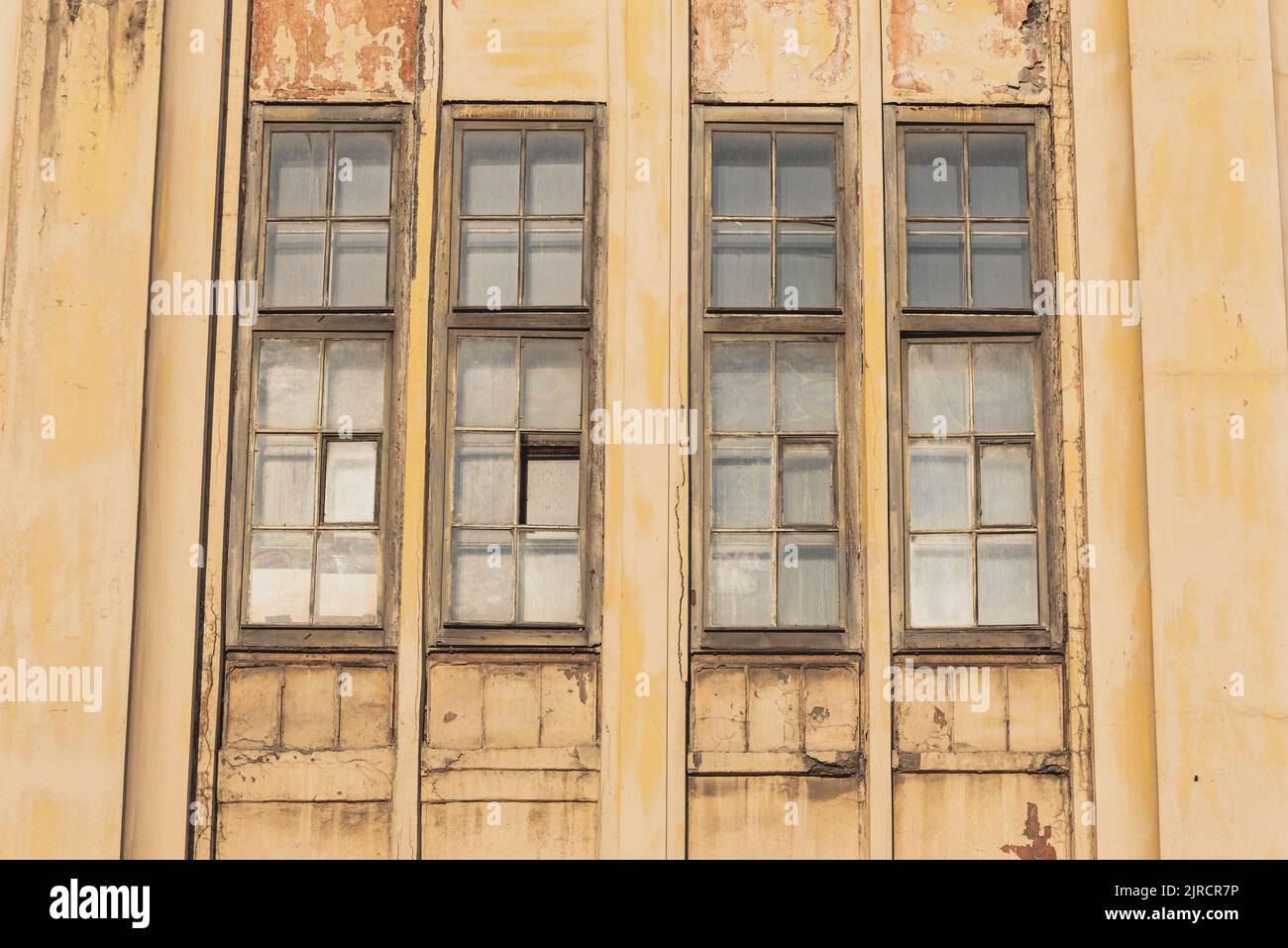 Schmale vertikale Fenster einer jahrhundertealten Fabrik. Nahaufnahme, historische Industriearchitektur Stockfoto