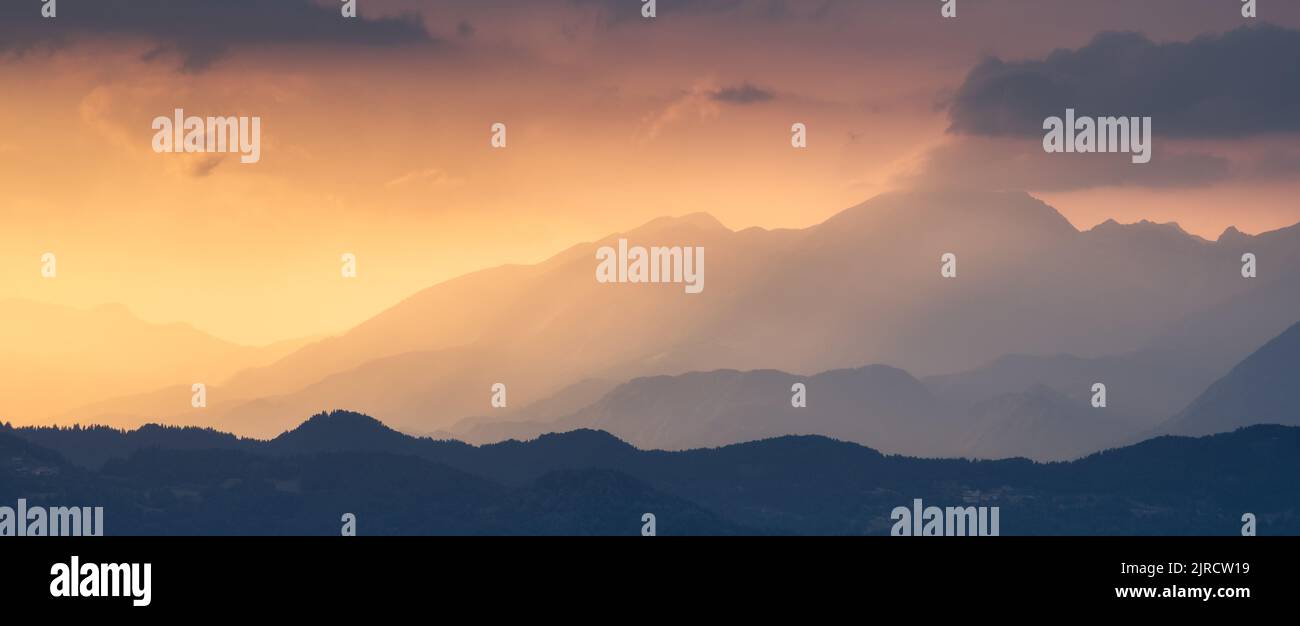 Erstaunliche Silhouetten von Bergen bei farbenfrohem Sonnenuntergang im Sommer Stockfoto