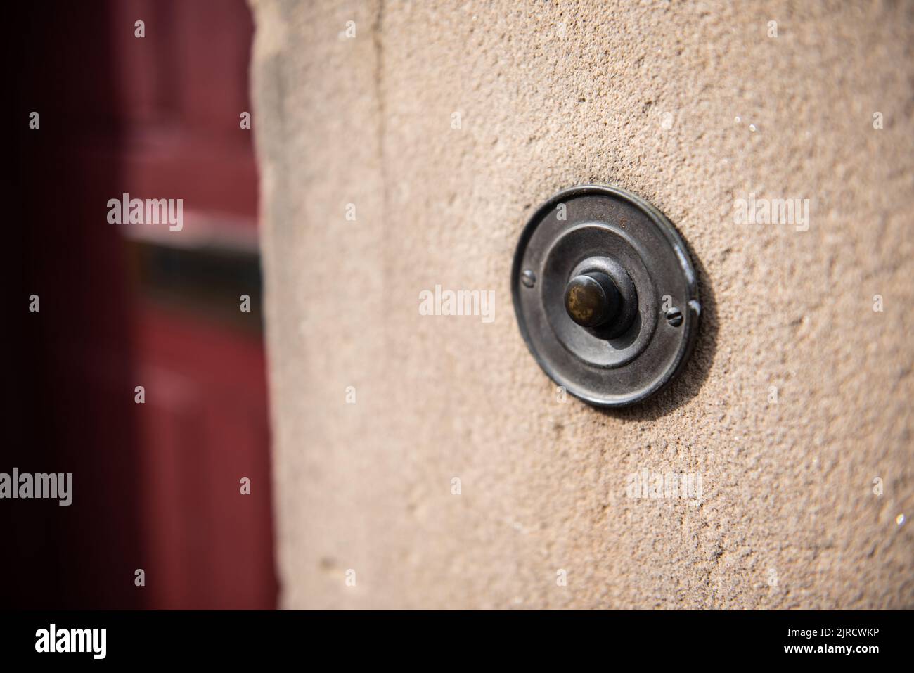 Antike Messingglocke mit grüner Patina vor der Haustür. Stockfoto