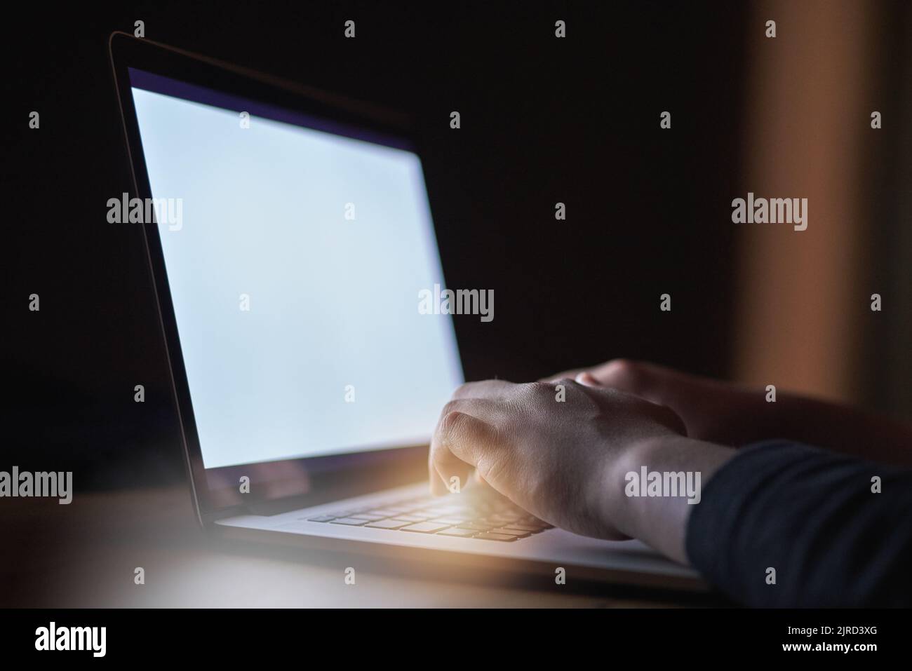Es gibt kein System, das er nicht hacken kann. Ein nicht erkennbarer Hacker, der im Dunkeln einen Laptop benutzt. Stockfoto