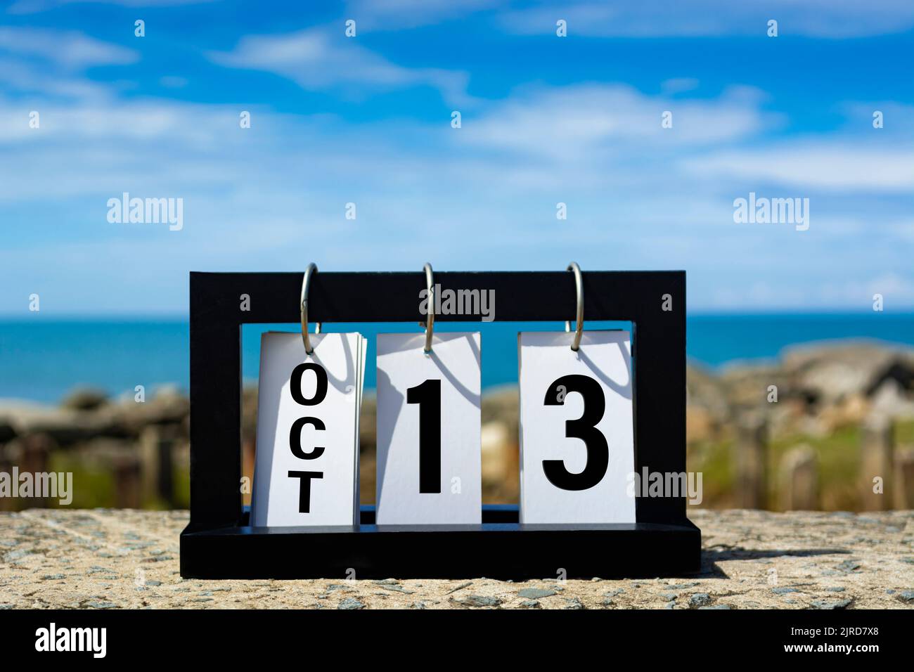 Okt. 13 Kalenderdatumstext auf Holzrahmen mit verschwommenem Hintergrund des Ozeans. Stockfoto