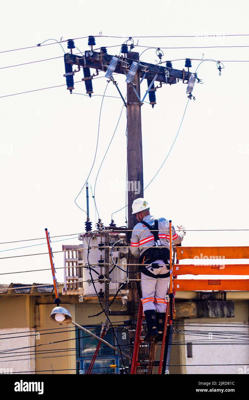 Ein Elektriker von Energiza klettert auf einen Pfosten, um Stromkabel in Mato Grosso do Sul zu befestigen. Ein Elektriker von Energiza, der die elektrische Übertragungsleitung und die Hochspannungsleitungen in Mato Grosso do Sul insphält. (Foto von Rafael Henrique/SOPA Images/Sipa USA) Quelle: SIPA USA/Alamy Live News Stockfoto