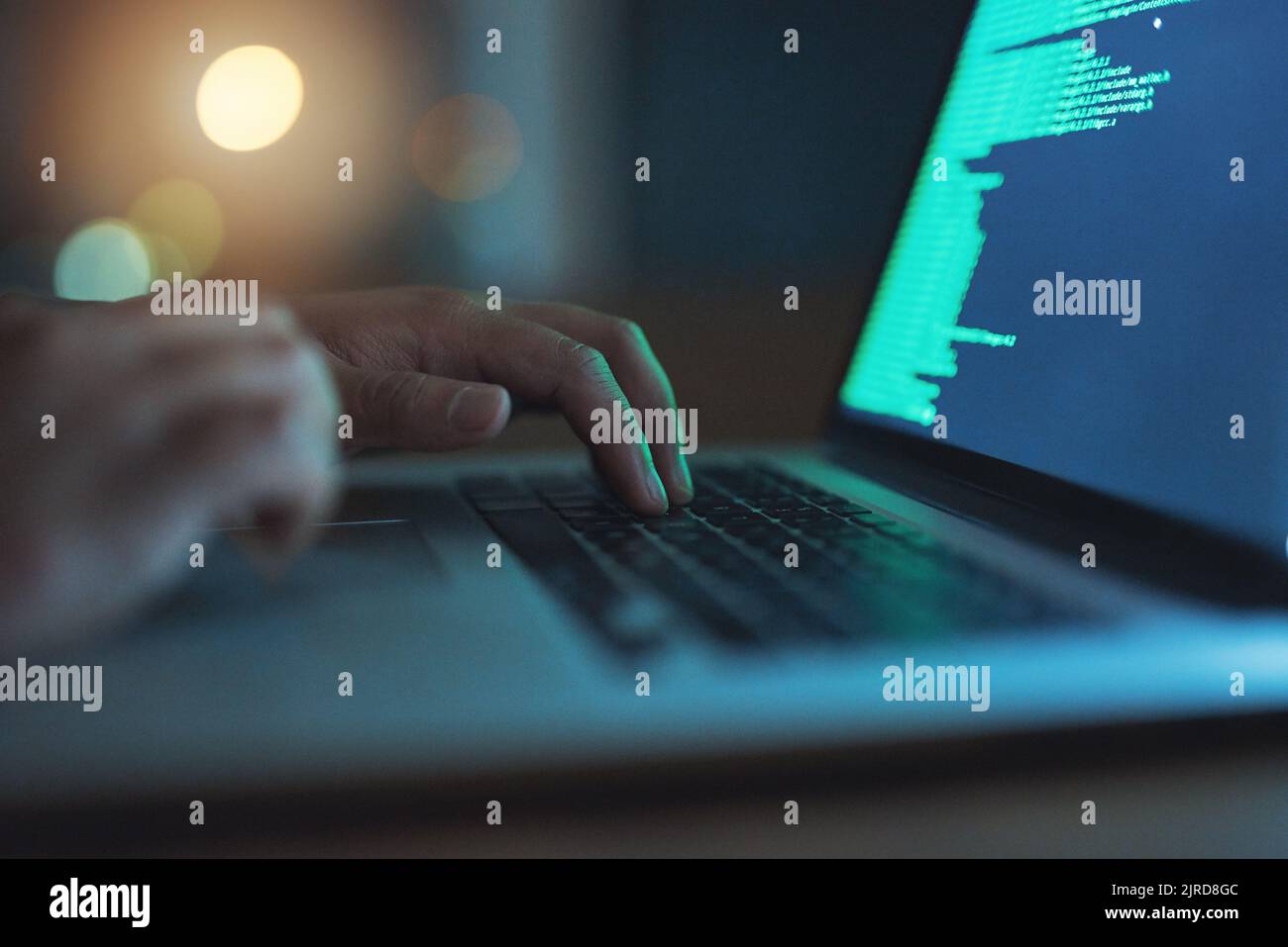 Cyberangriffe sind real, ein nicht erkennbarer Hacker, der im Dunkeln einen Laptop benutzt. Stockfoto